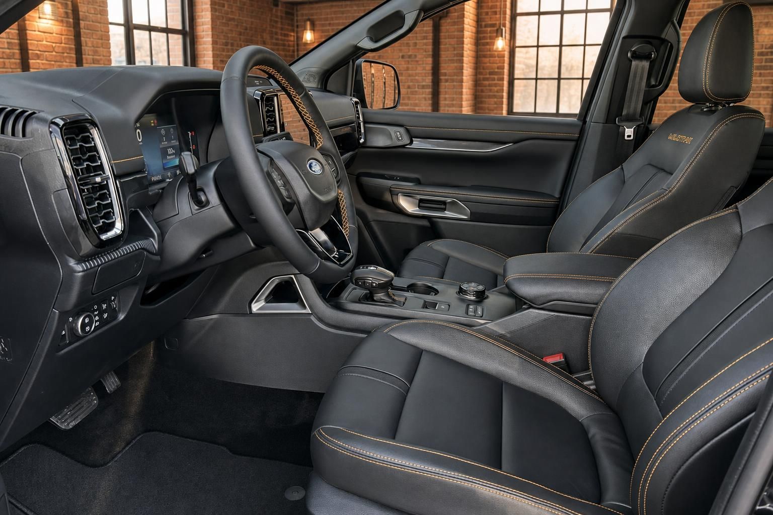 Ford Ranger Wildtrak Innenraum Fahrersitz schwarzes Leder mit goldenen Ziernähten und Touchscreen
