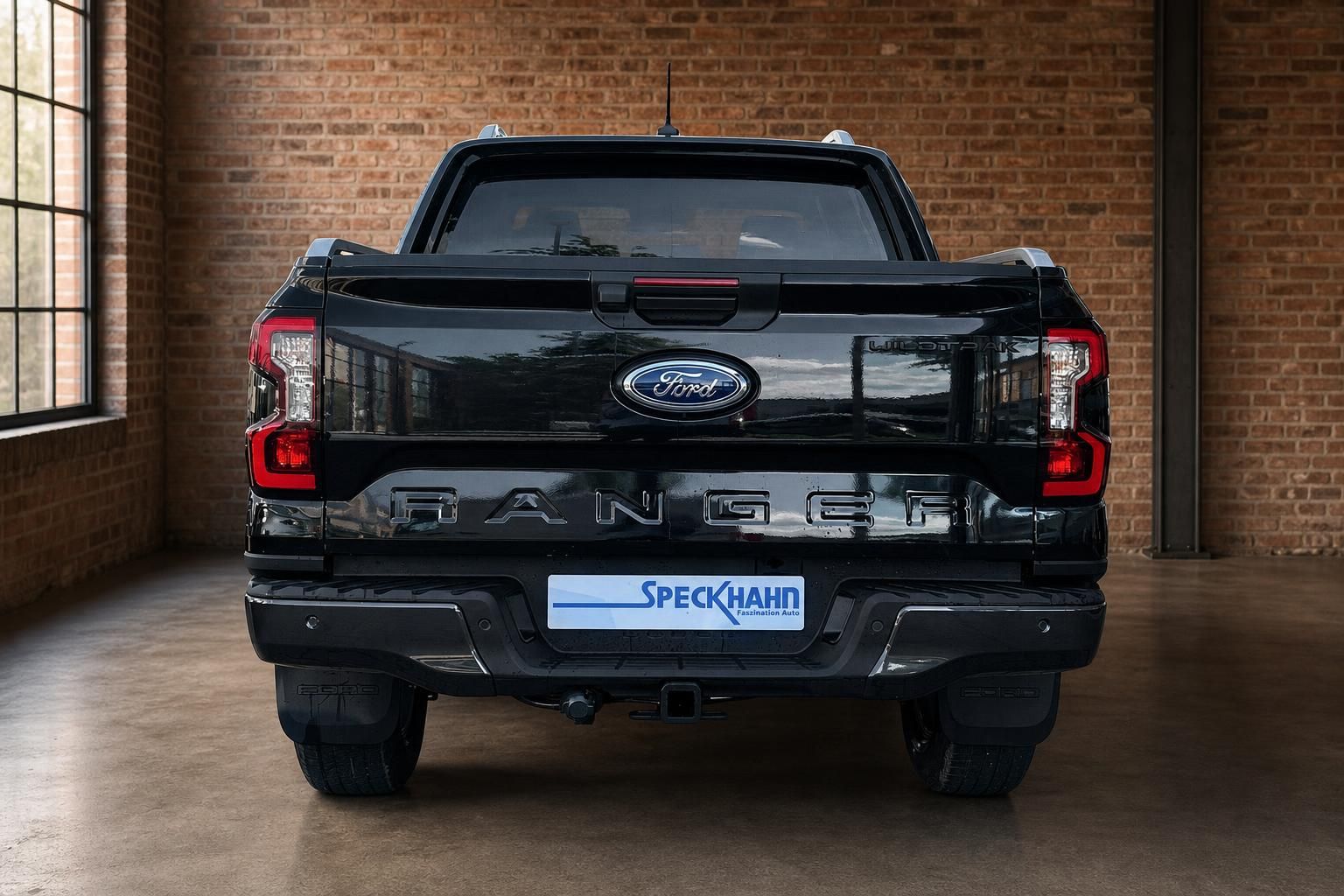Ford Ranger Wildtrak schwarz direkte Heckansicht mit Anhängerkupplung im Showroom