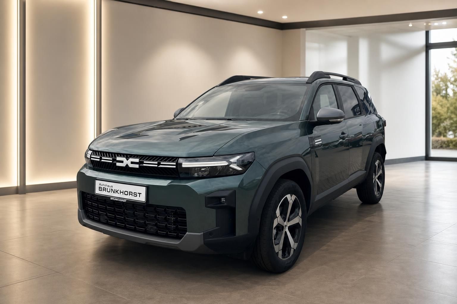 Dacia Bigster SUV in graugrün von vorne im modernen Autohaus Showroom