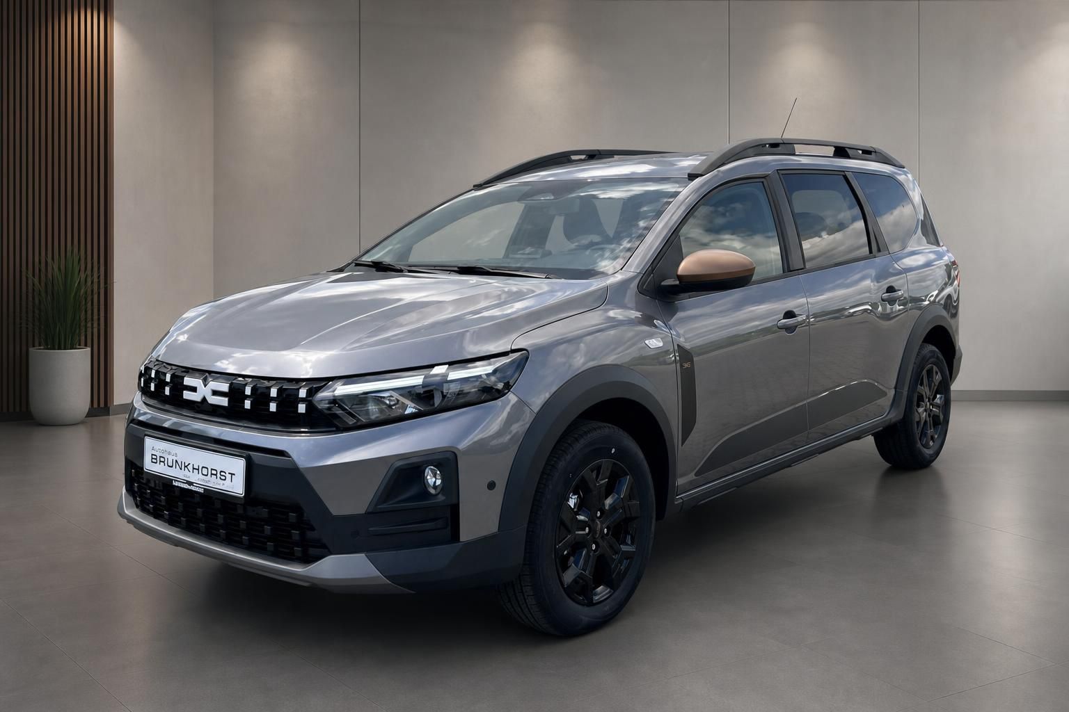 Dacia SUV grau Seitenansicht im modernen Autohaus Showroom