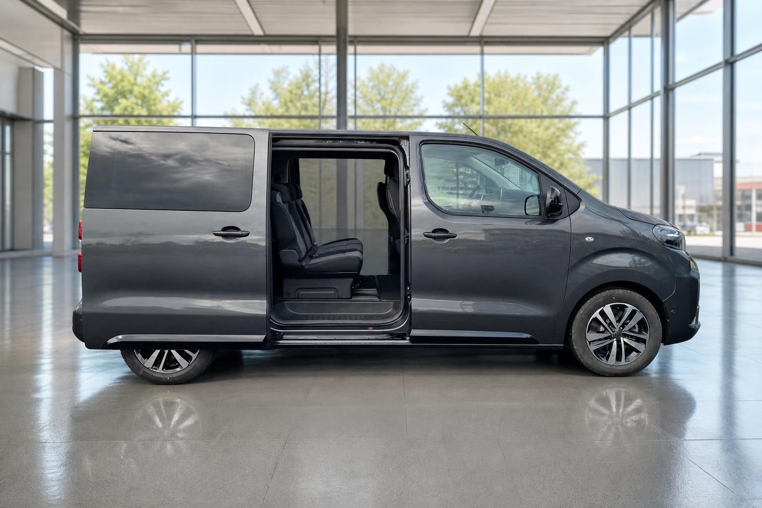 Peugeot Traveller Seitenansicht mit offener Tür präsentiert geräumigen Innenraum in eleganter Showroom-Atmosphäre