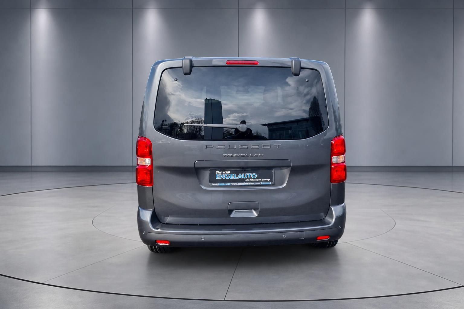 Peugeot Traveller von hinten mit Händlerkennzeichen und elegantem Design auf drehbarer Plattform präsentiert