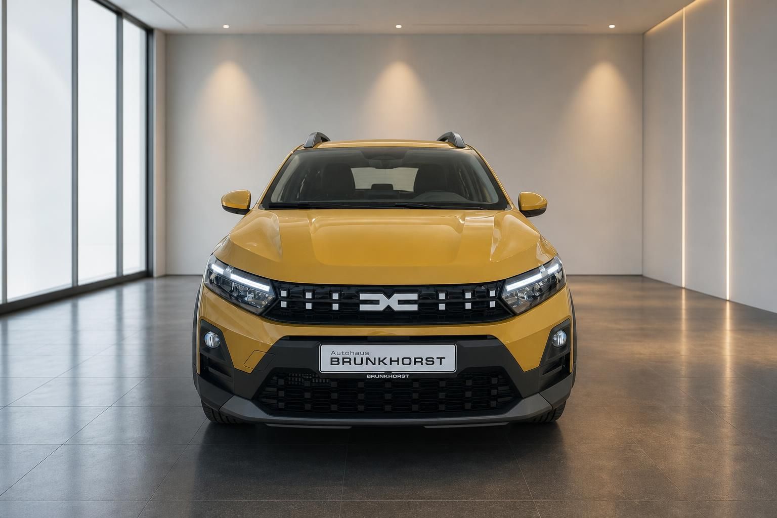 Gelber Dacia SUV Frontansicht mit schwarzem Kühlergrill und LED-Scheinwerfern im Autohaus