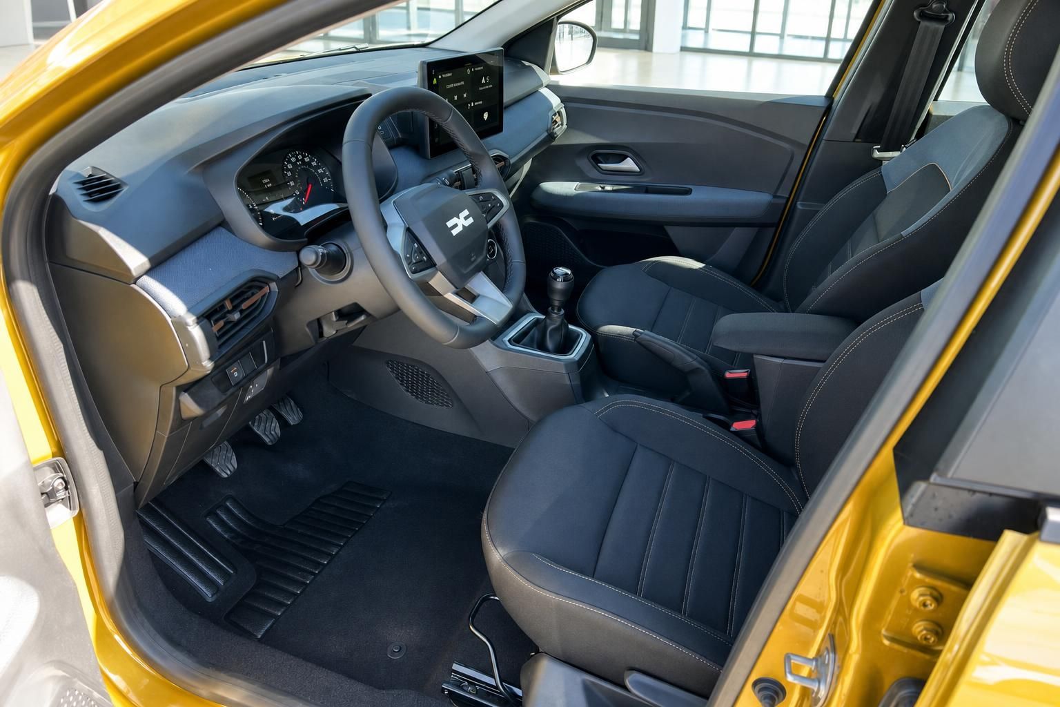 Dacia SUV Fahrersitz mit schwarzer Ausstattung, Mittelkonsole und Touchscreen-Infotainment