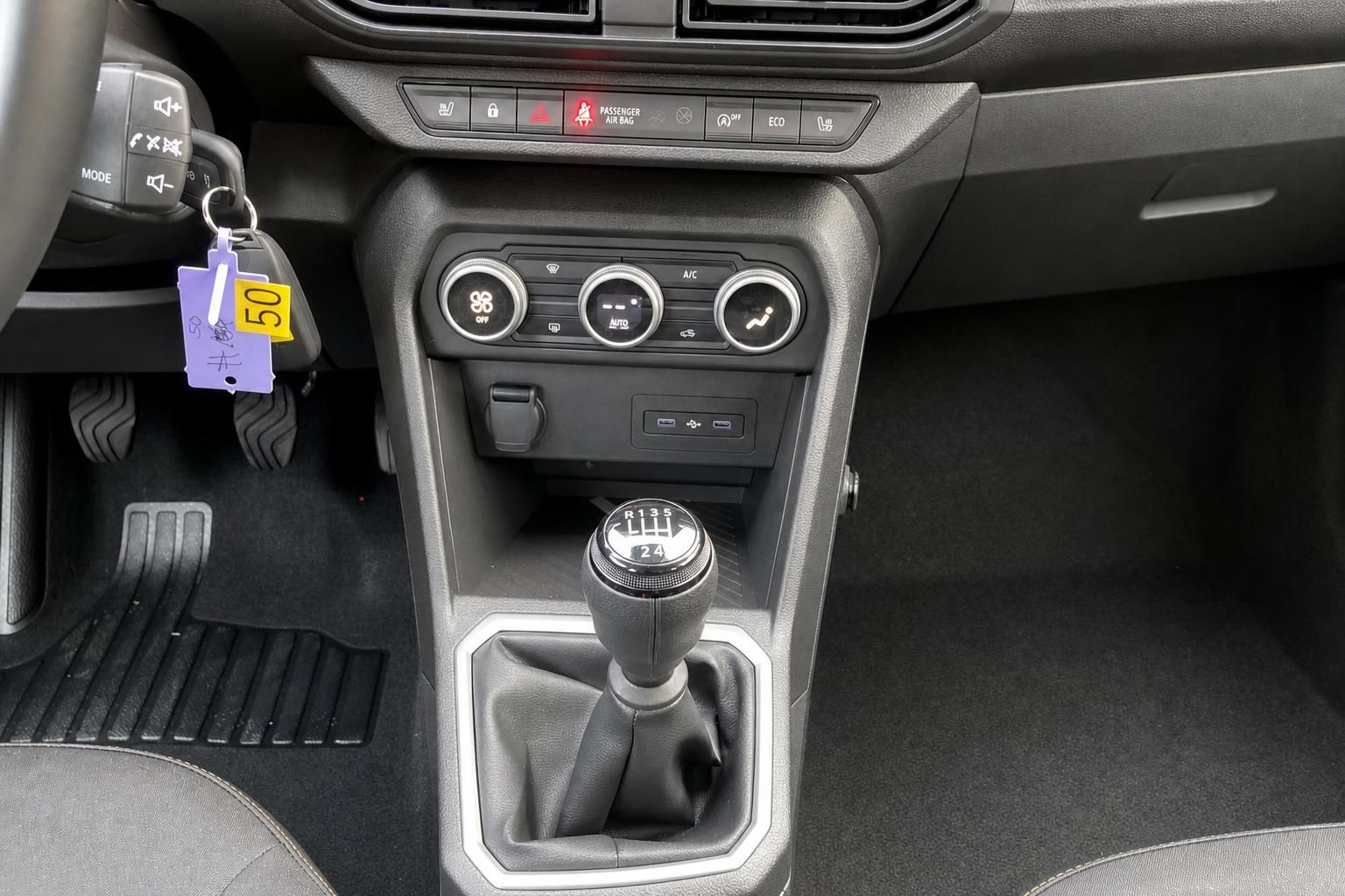 Mittelkonsole Auto mit Schaltknauf, Klimaanlage und violettem Schluesselanhaenger