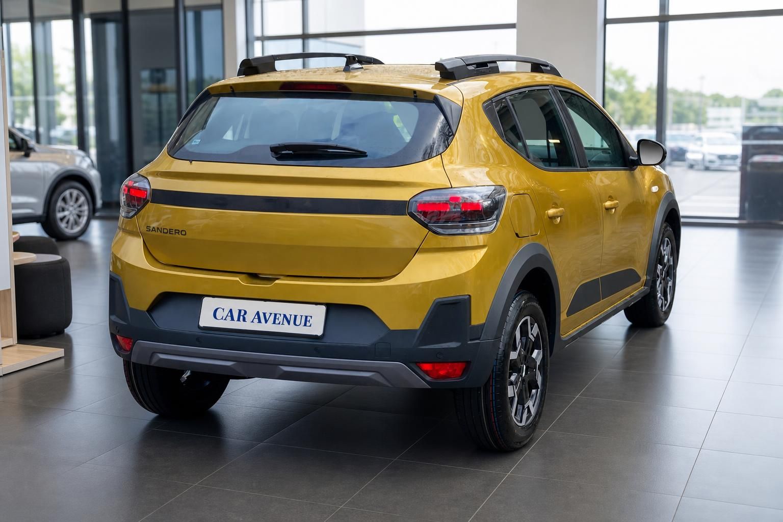 Gelber Dacia Sandero Rückansicht schräg mit Car Avenue Kennzeichen im Autohaus