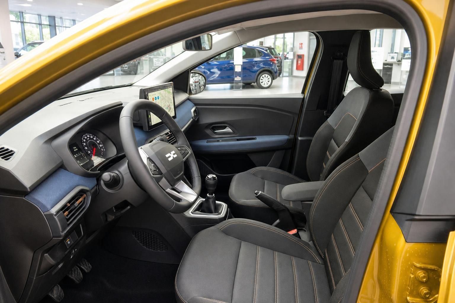 Innenraum gelbes Auto mit schwarzen Sitzen, Lenkrad und Touchscreen Display