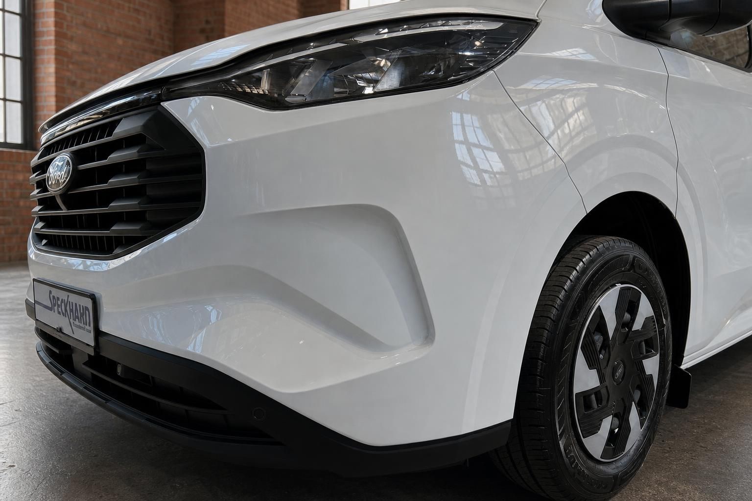 Ford Transit Custom Detail Frontpartie – Ford-Logo, Scheinwerfer und schwarze Felge in Nahaufnahme