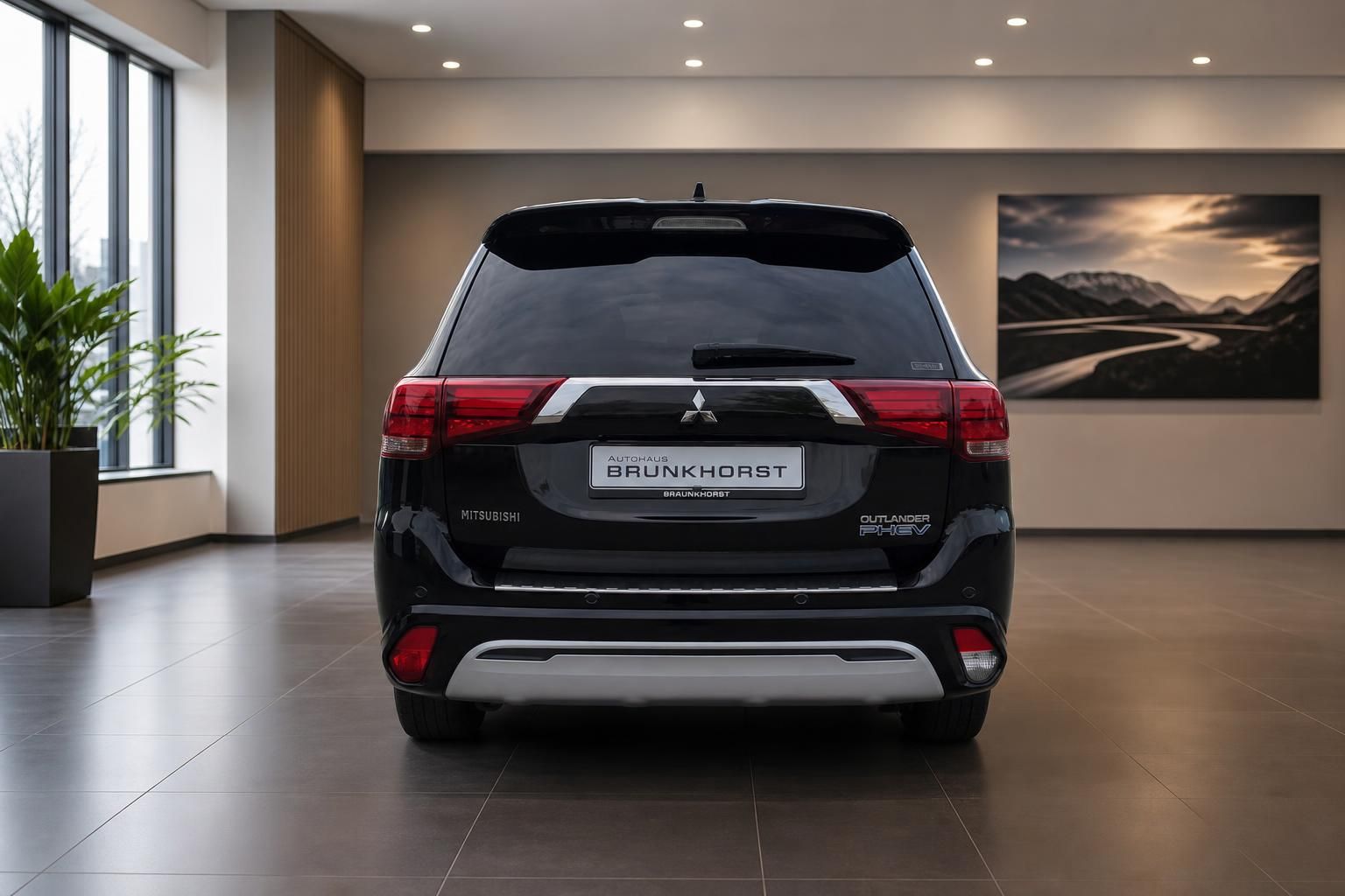 Schwarzer Mitsubishi Outlander PHEV SUV Heckansicht im Autohaus Showroom