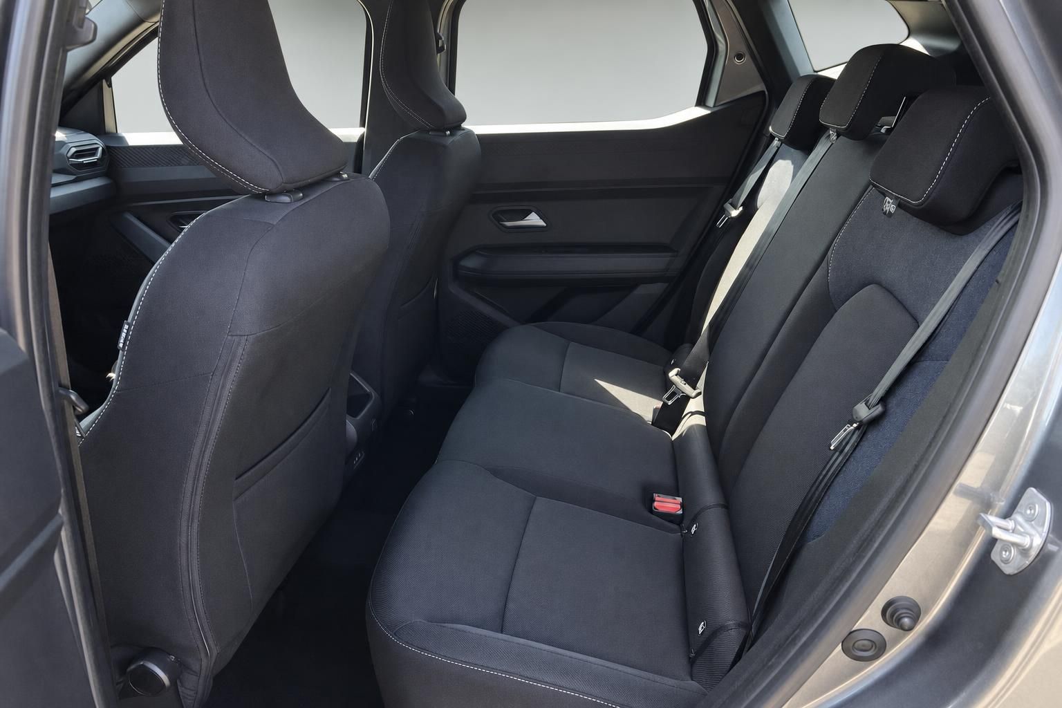 Rücksitzbank des Fahrzeugs mit schwarzer Polsterung und Sicherheitsgurten