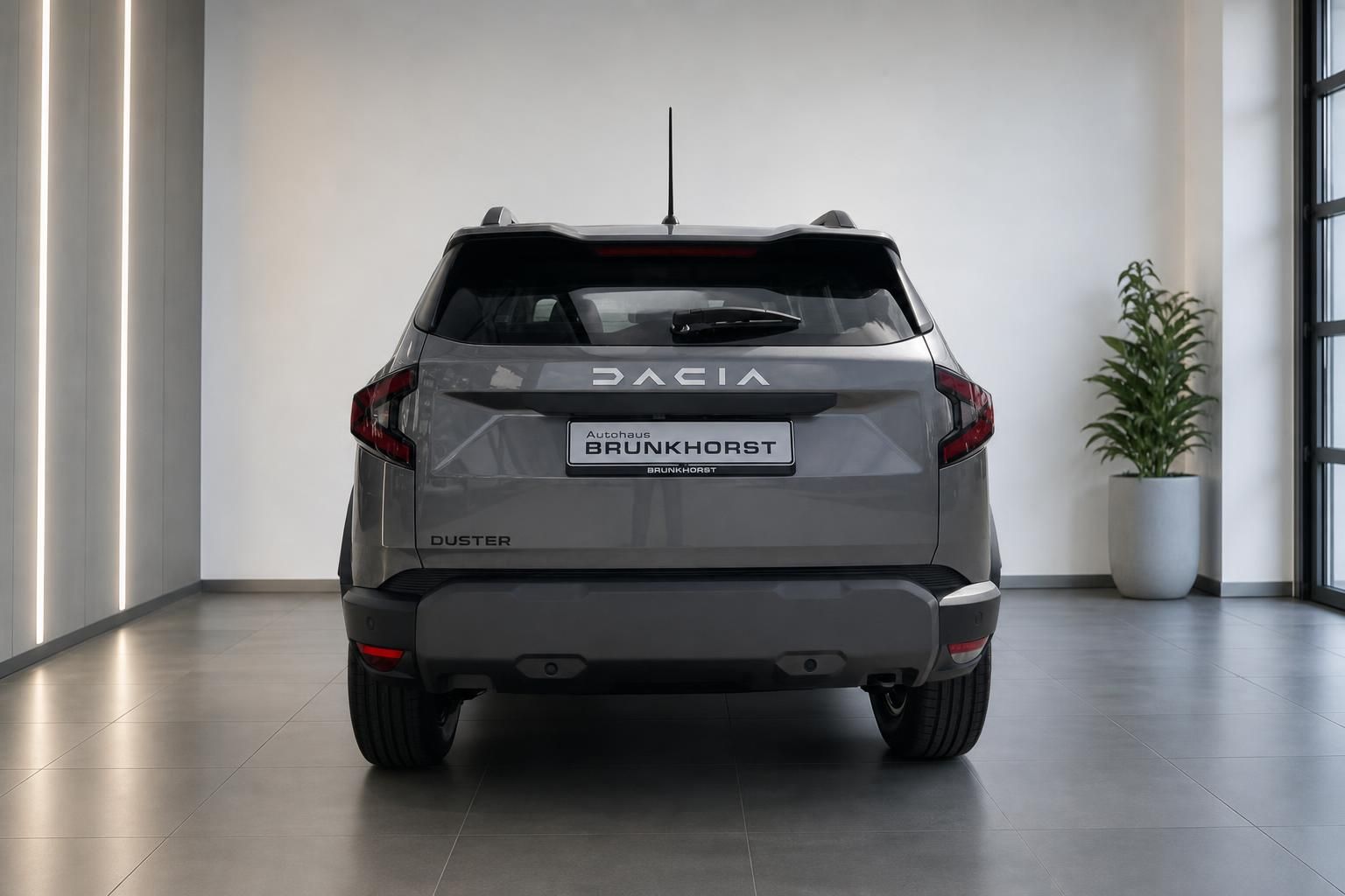 Dacia Duster Heckansicht in grau, SUV von hinten im Autohaus Showroom