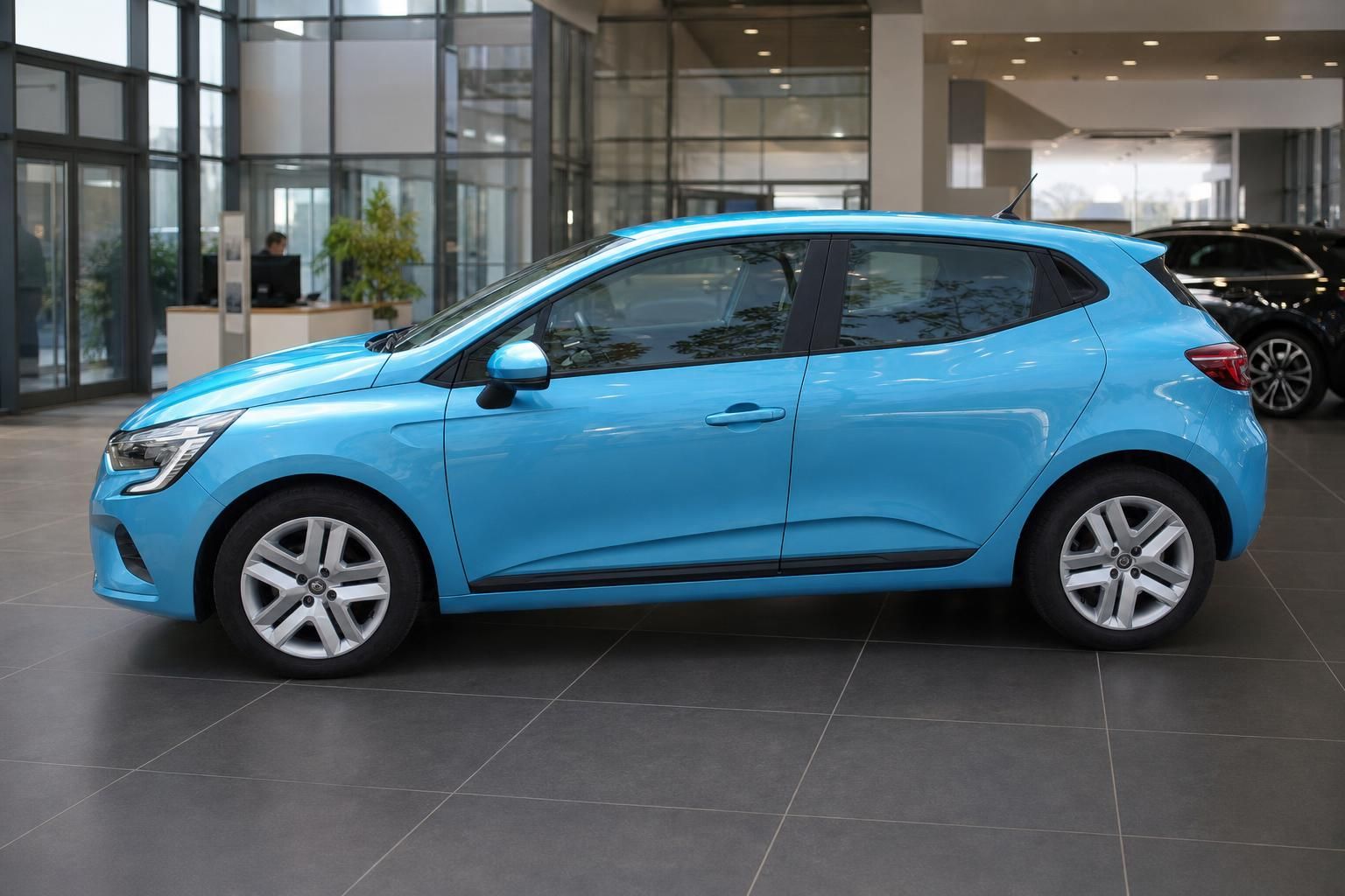 Blauer Renault Clio Seitenansicht links im Showroom - kompakter Kleinwagen mit sportlicher Optik
