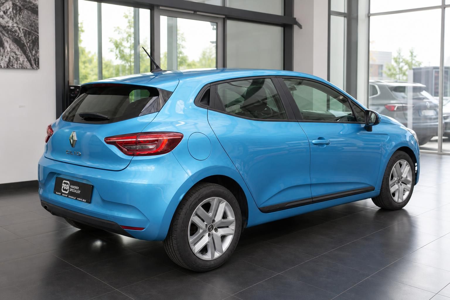 Blauer Renault Clio von hinten rechts im Autohaus-Showroom fotografiert