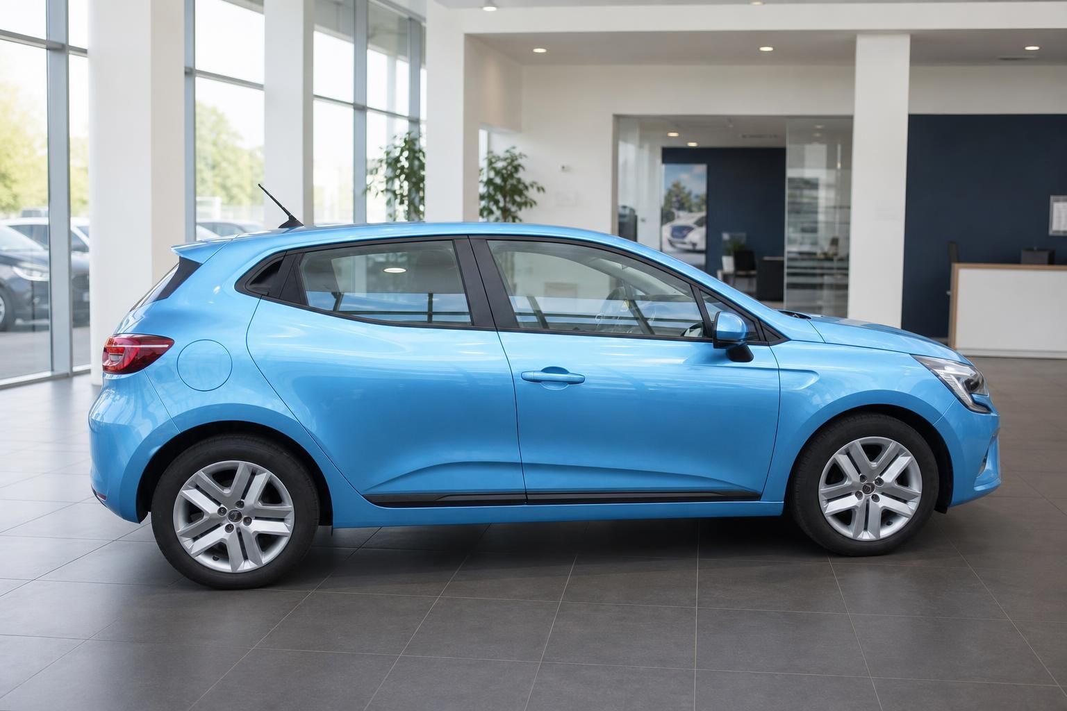 Seitenansicht des blauen Renault Clio mit Aluminiumfelgen im Showroom