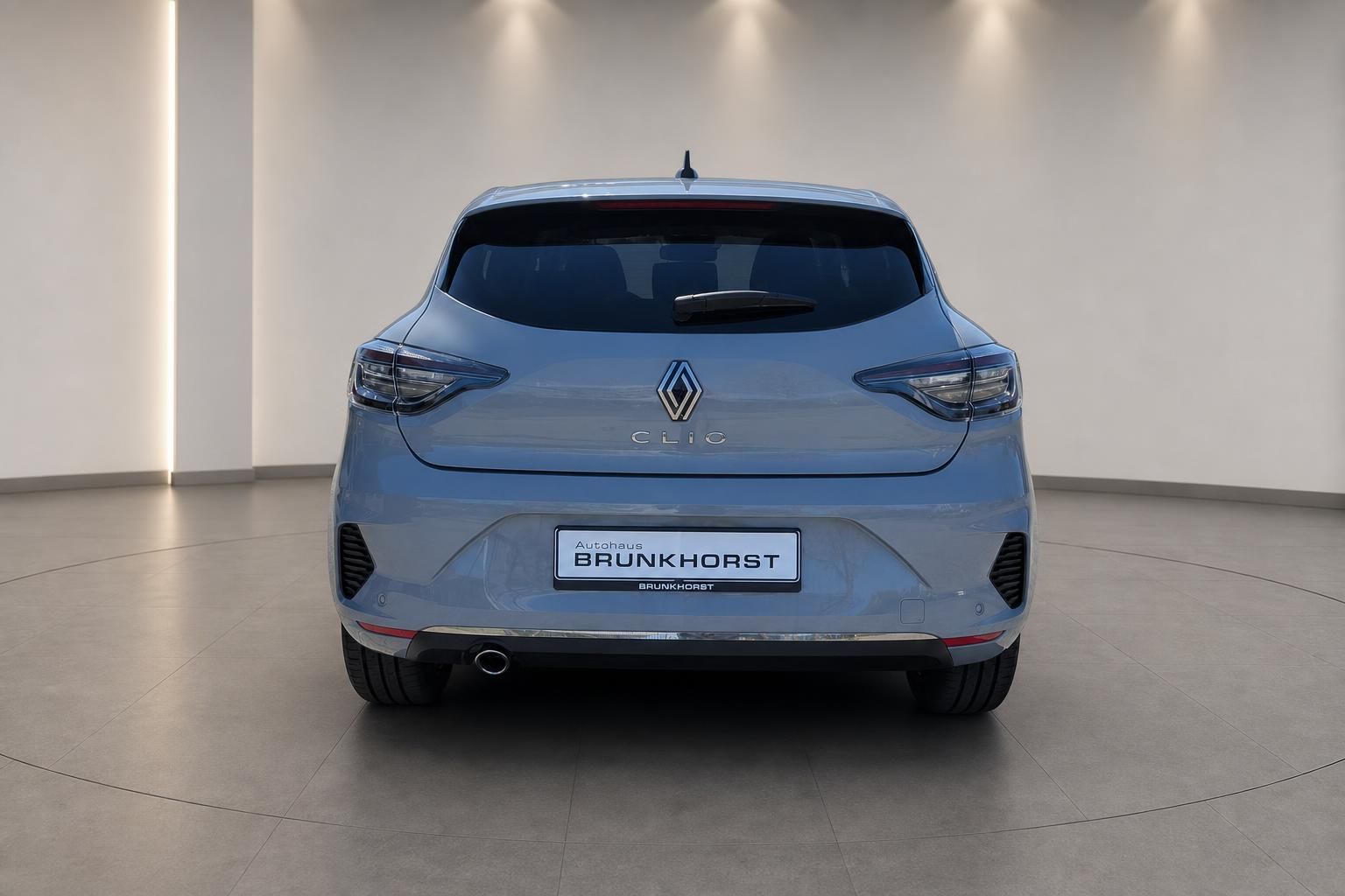 Renault Clio Heckansicht in silberblau mit LED-Rückleuchten im modernen Showroom