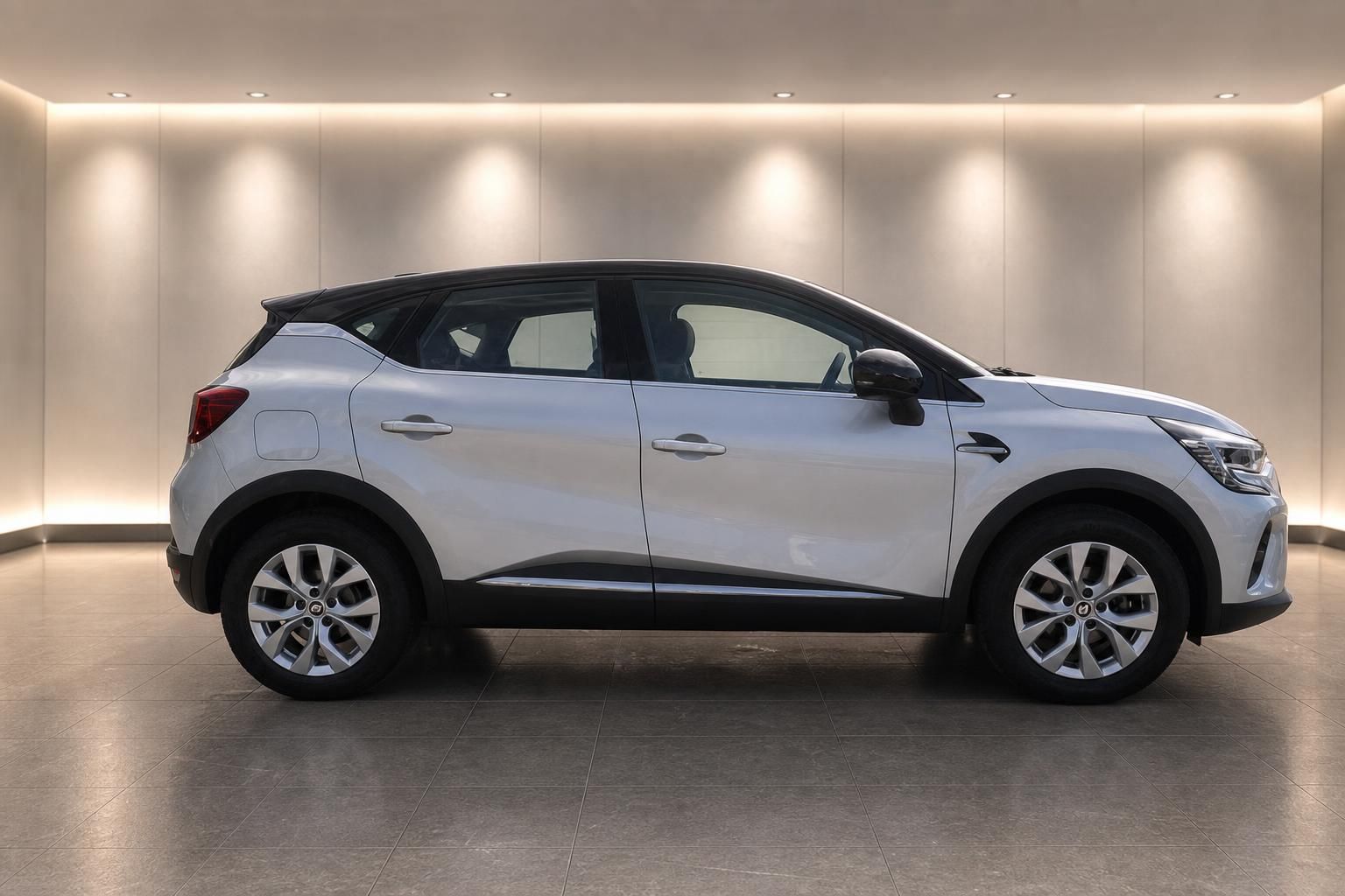 Renault Captur weiß Seitenansicht – kompakter SUV mit schwarzem Dach im Autohaus
