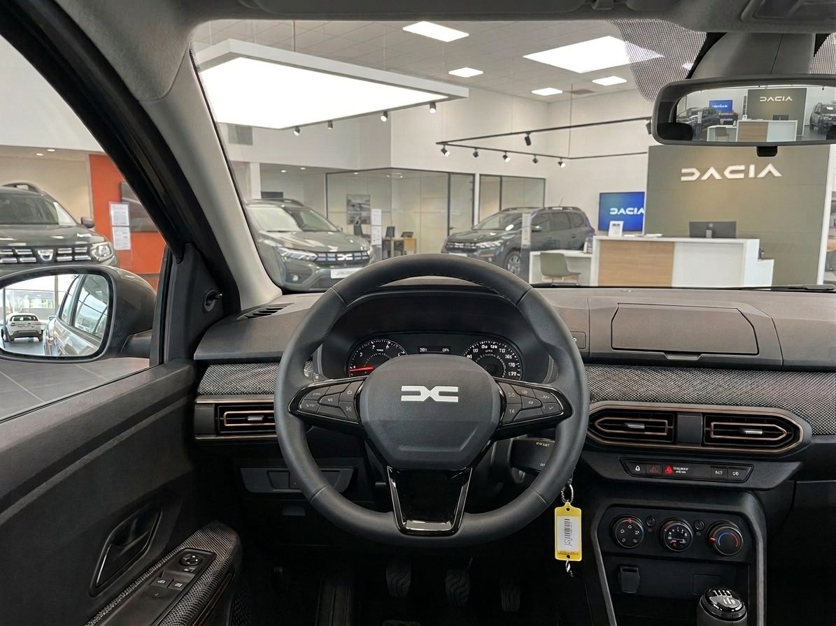 Dacia Cockpit-Ansicht mit Lenkrad, Instrumententafel und Mittelkonsole in grauer Ausstattung