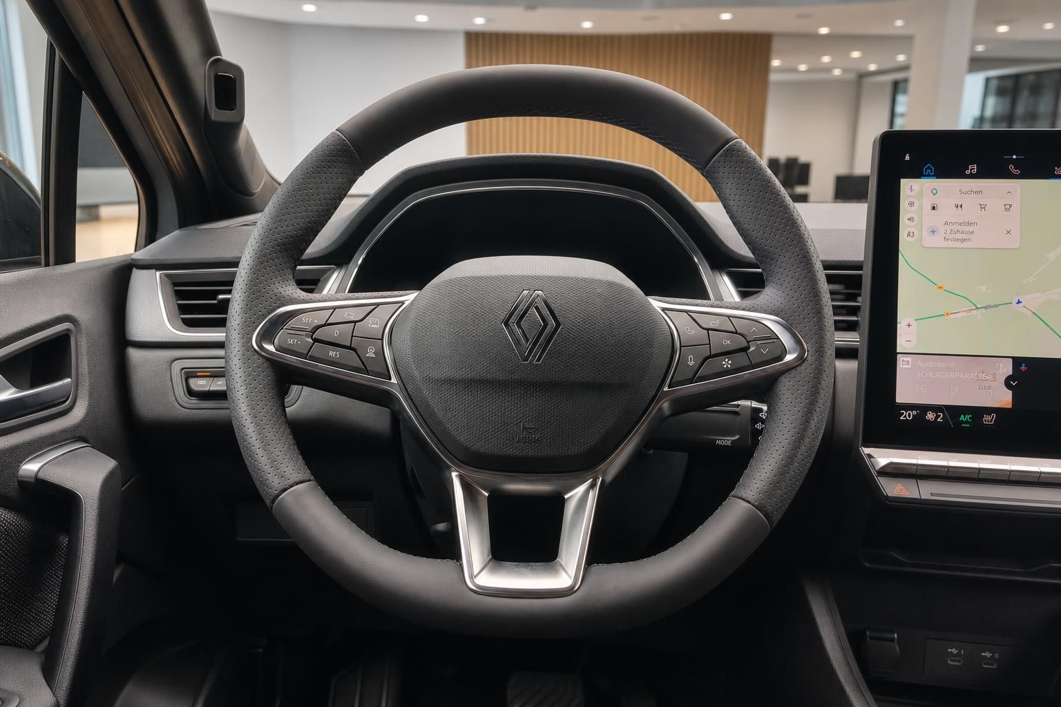 Renault Lenkrad mit Multifunktionstasten und digitalem Touchscreen im Hintergrund