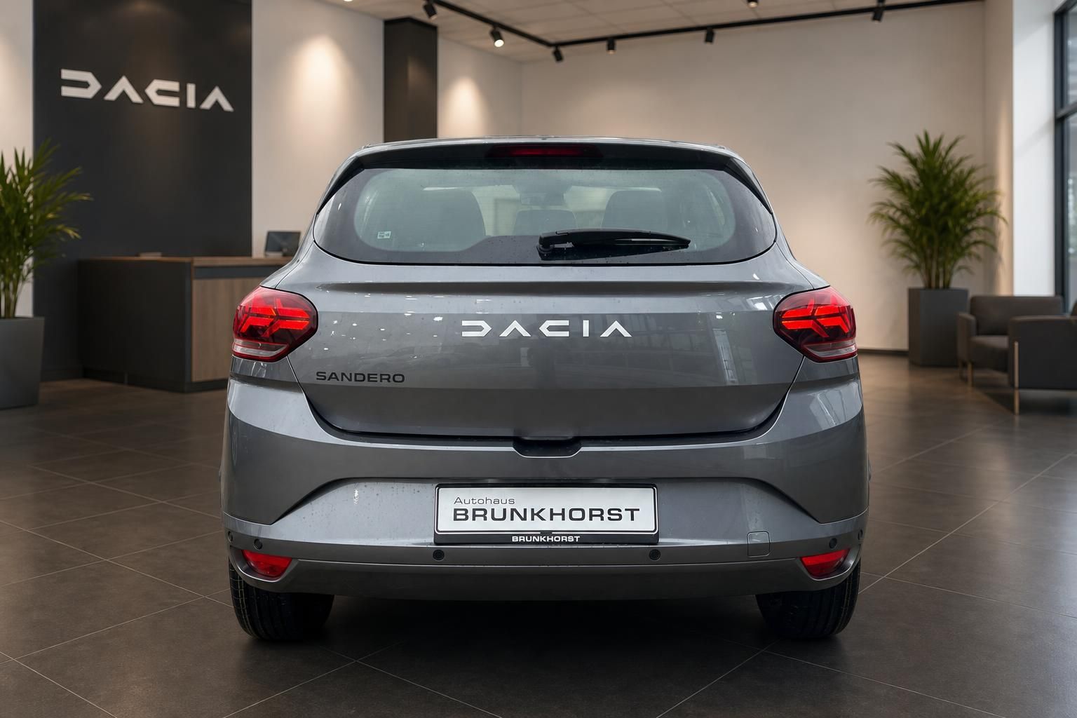 Dacia Sandero grau metallic Heckansicht mit roten Rücklichtern im Autohaus Brunkhorst
