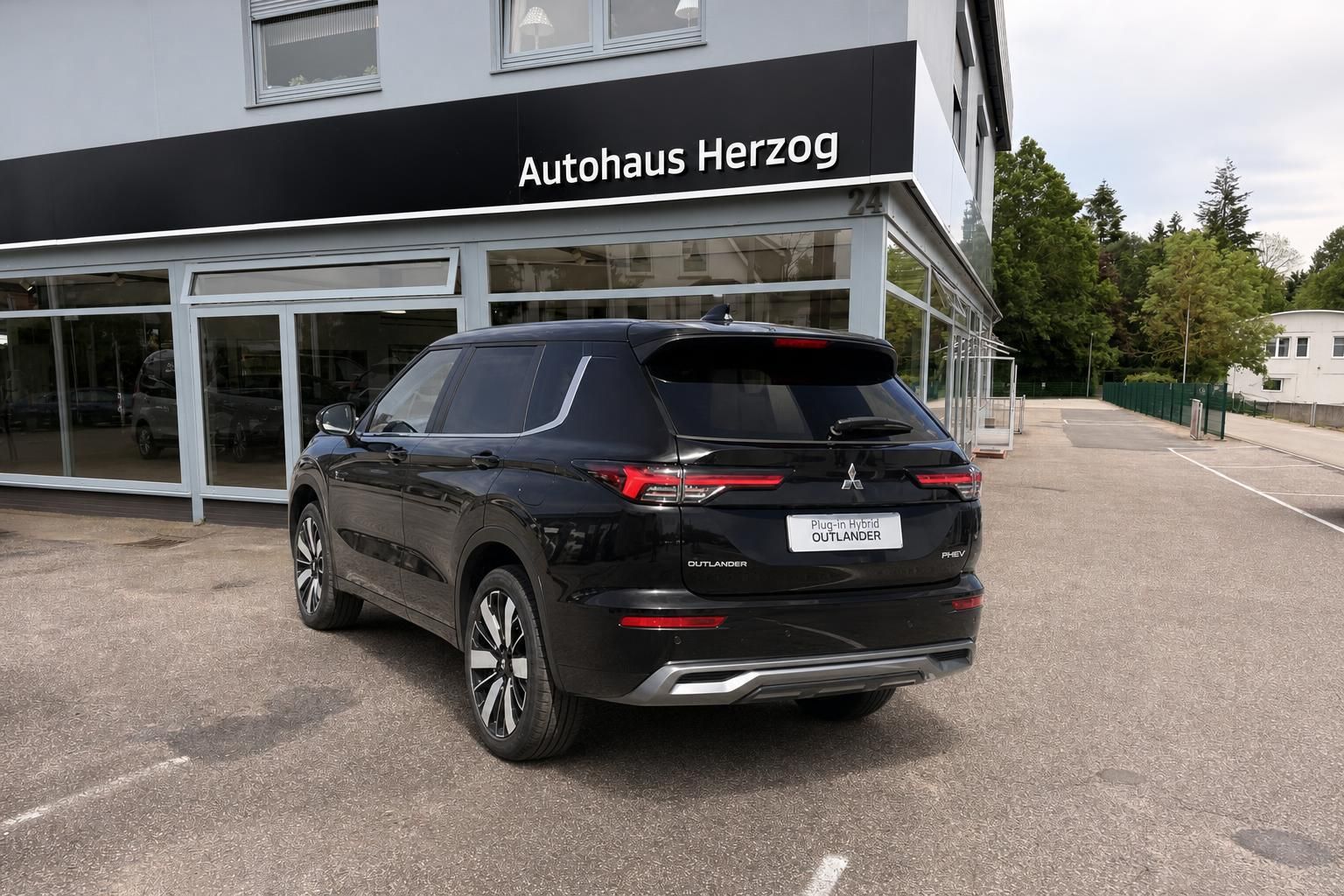 Mitsubishi Outlander Plug-in Hybrid SUV schwarz, Dreiviertel-Heckansicht mit Kennzeichen