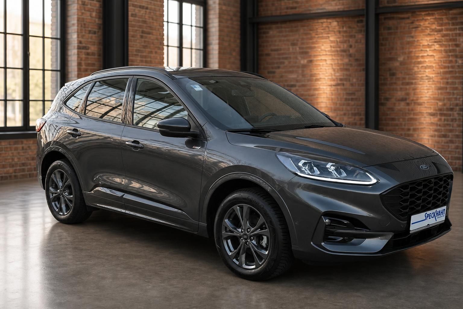 Ford Kuga grau metallic in Industriehalle, Seitenansicht schraeg vorne