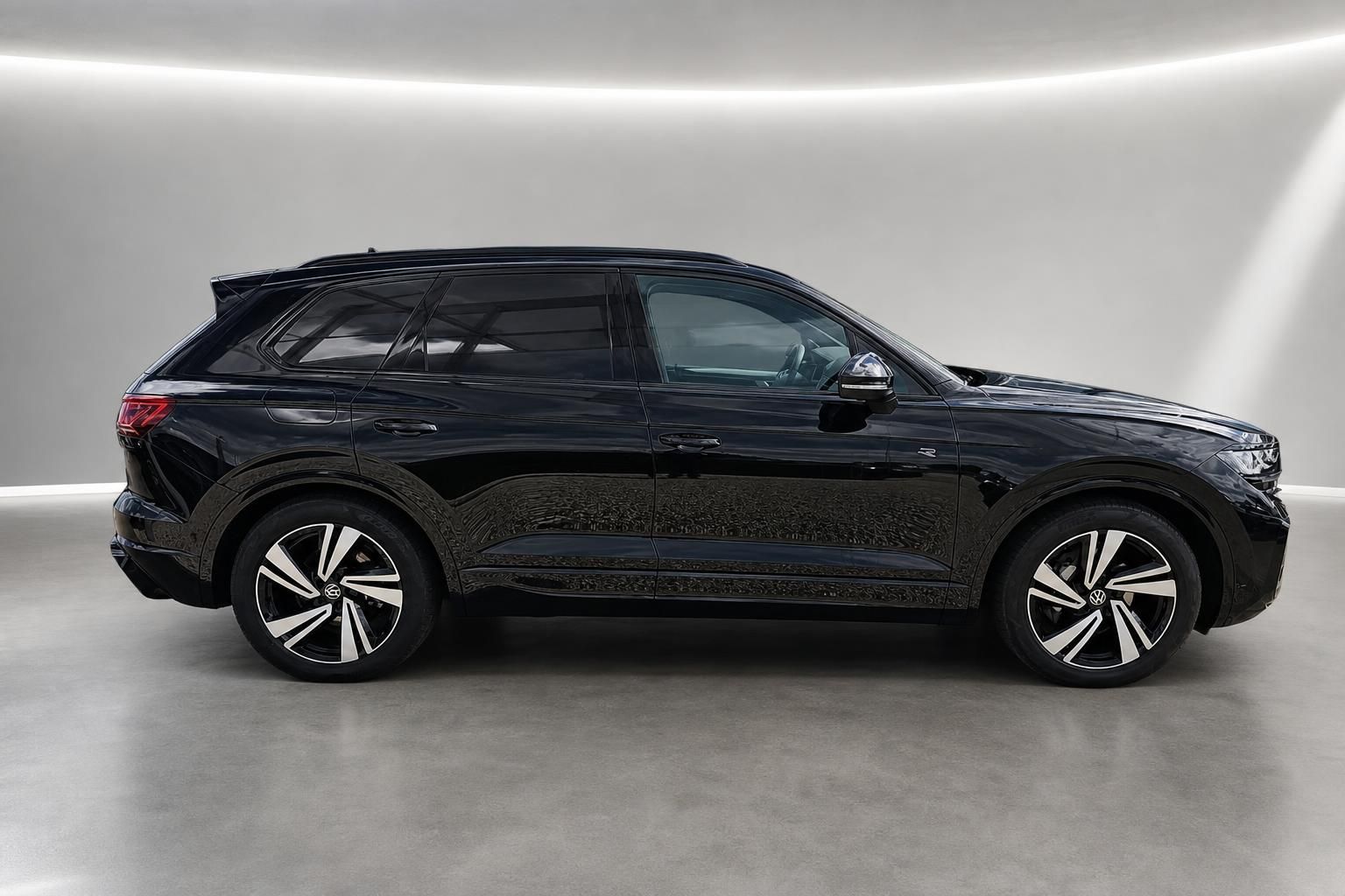 VW Touareg schwarz Seitenansicht im modernen Showroom