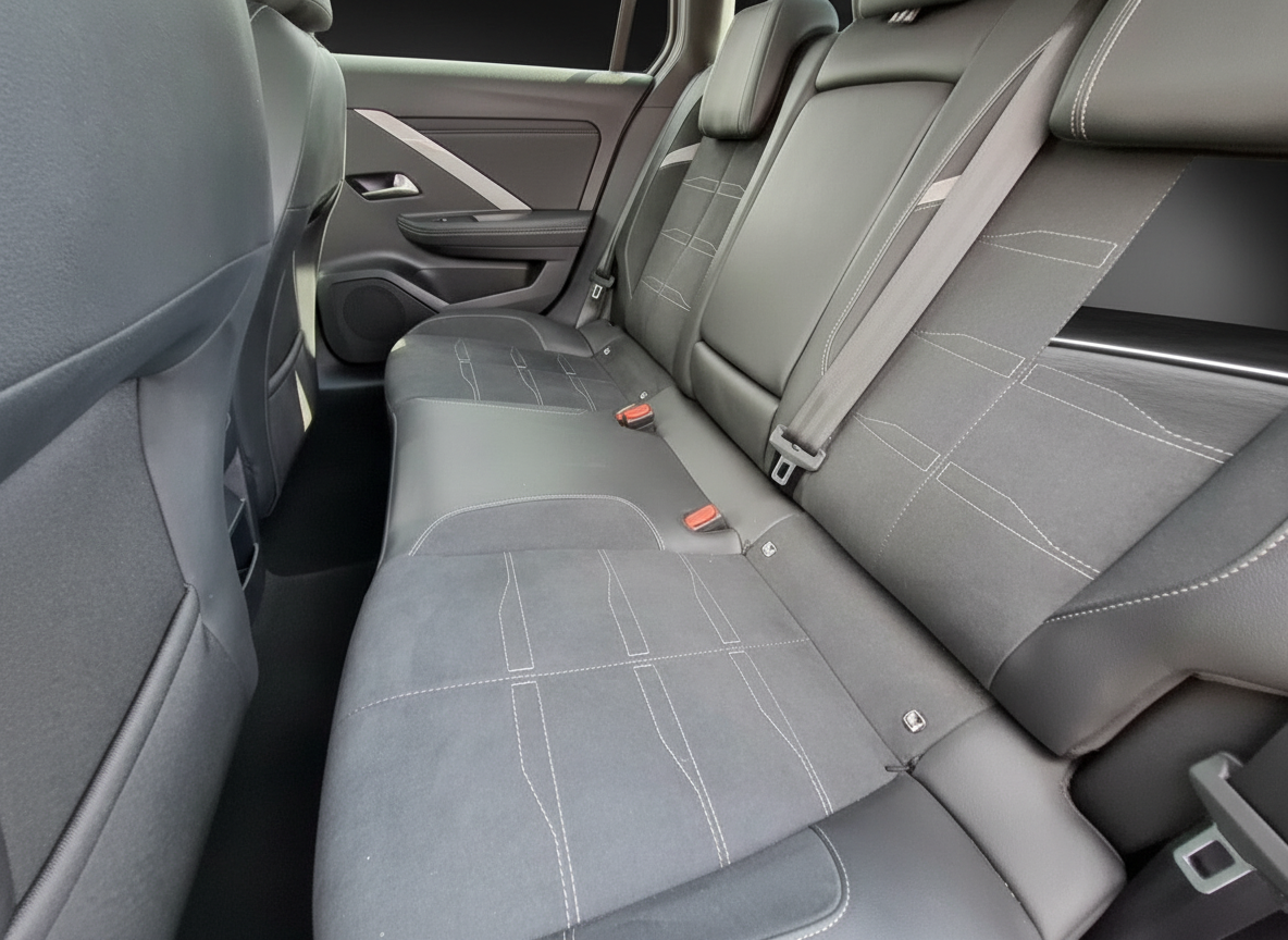 Fahrzeuginnenraum Rücksitzbank grau mit weißen Ziernähten und Sicherheitsgurten