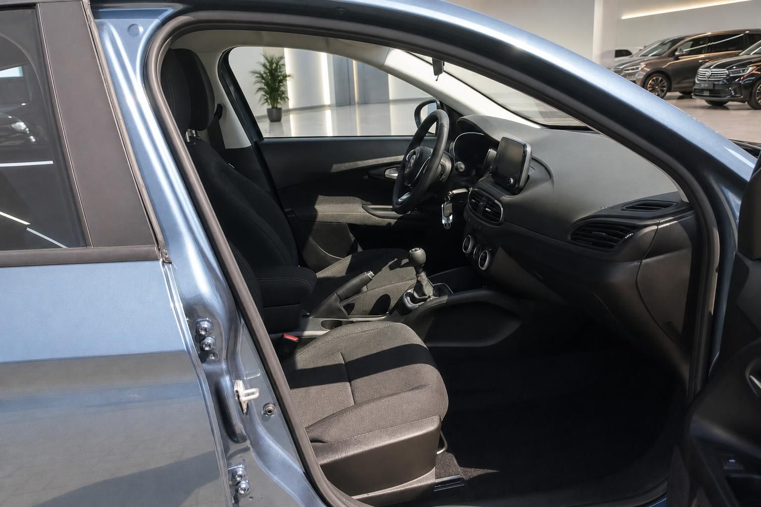 Fiat Tipo Innenraum Fahrerseite geöffnet mit Vordersitzen und Schaltgetriebe im Autohaus