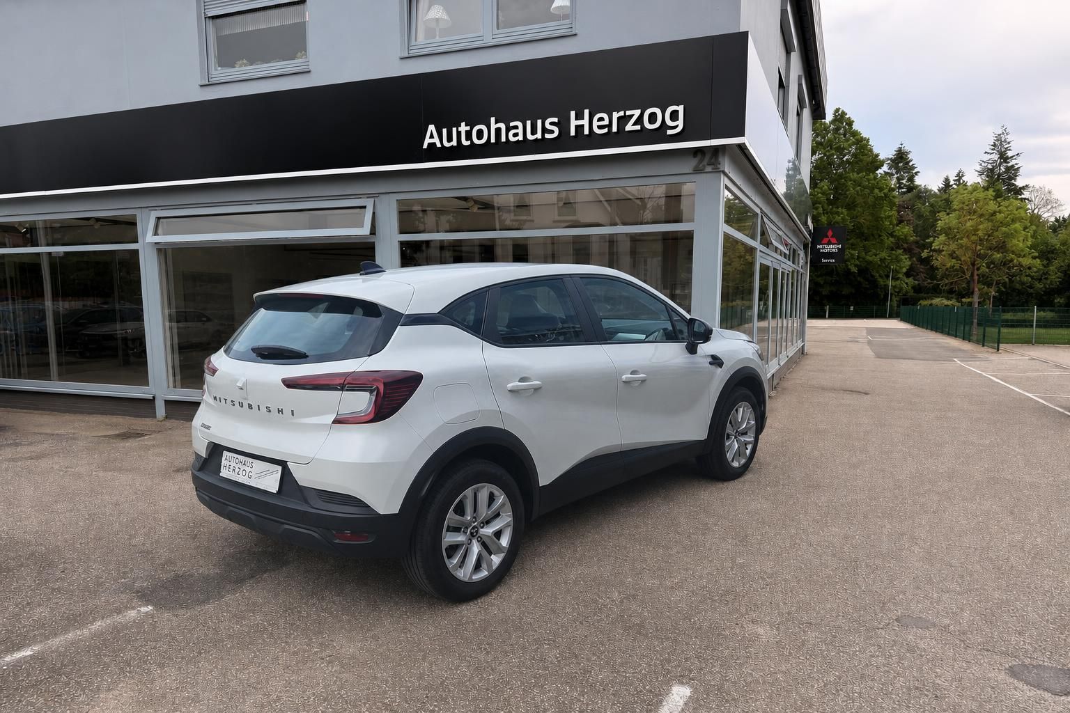 Mitsubishi SUV weiß Heckansicht mit Händlerkennzeichen vor Autohaus Herzog