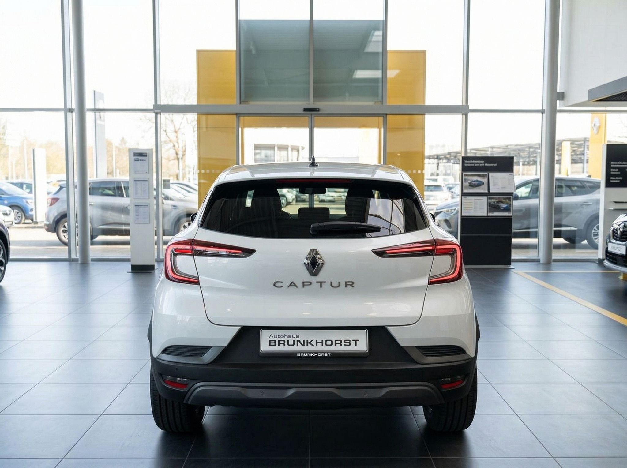Renault Captur weiss Heckansicht im Autohaus, LED-Rückleuchten und CAPTUR Schriftzug sichtbar