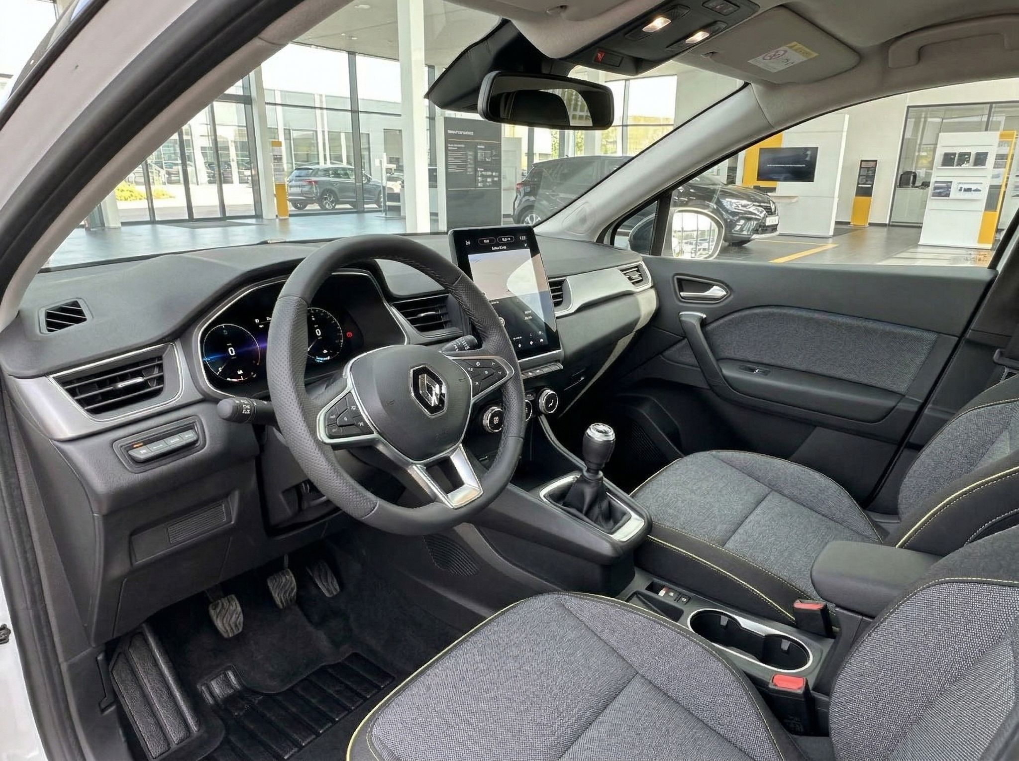 Renault Captur Innenraum mit Lenkrad, Touchscreen-Display und Stoff-Sitzen in grau