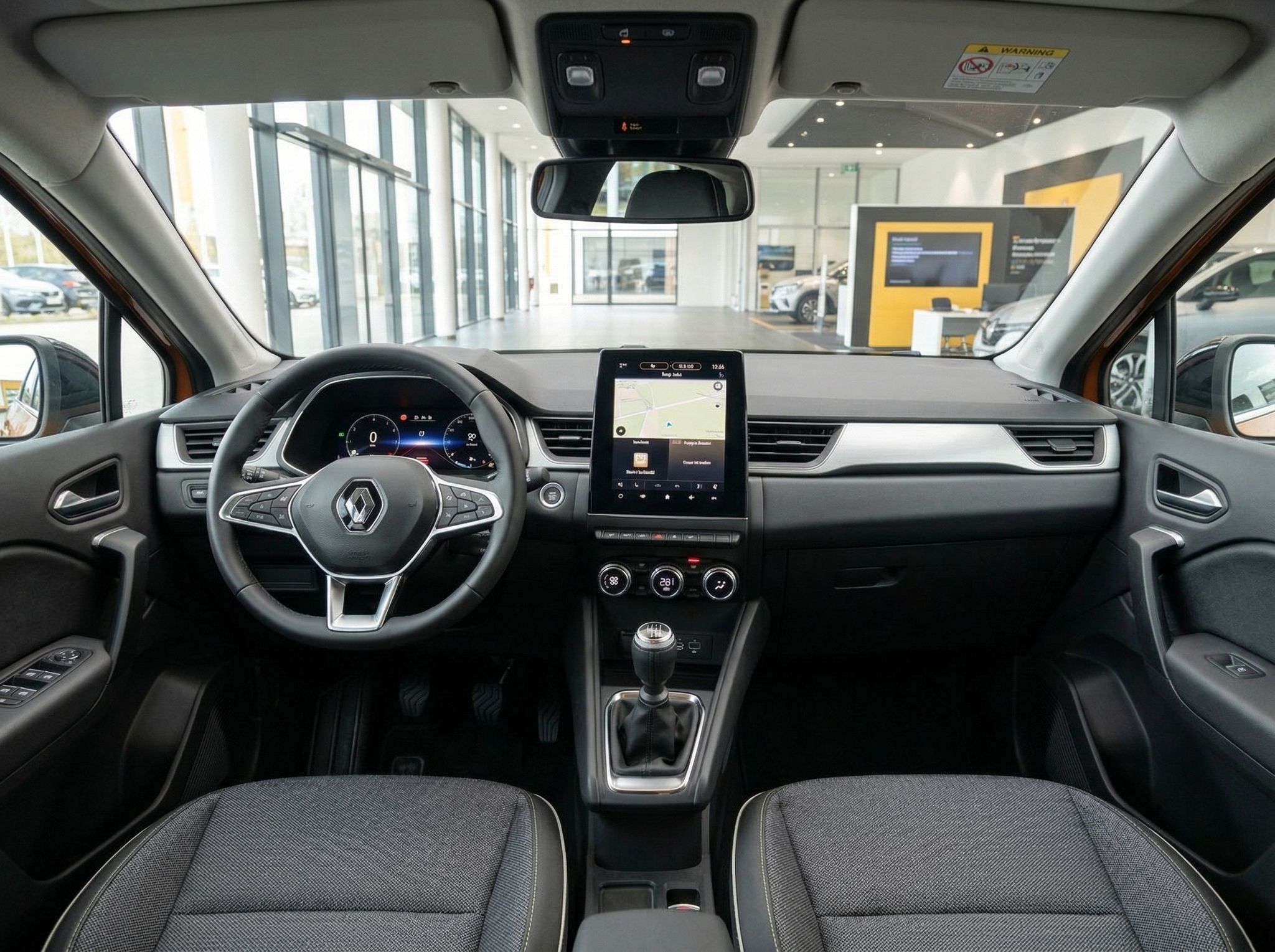 Renault Fahrzeug Innenraum mit Lenkrad, Touchscreen und grauem Interieur im Autohaus
