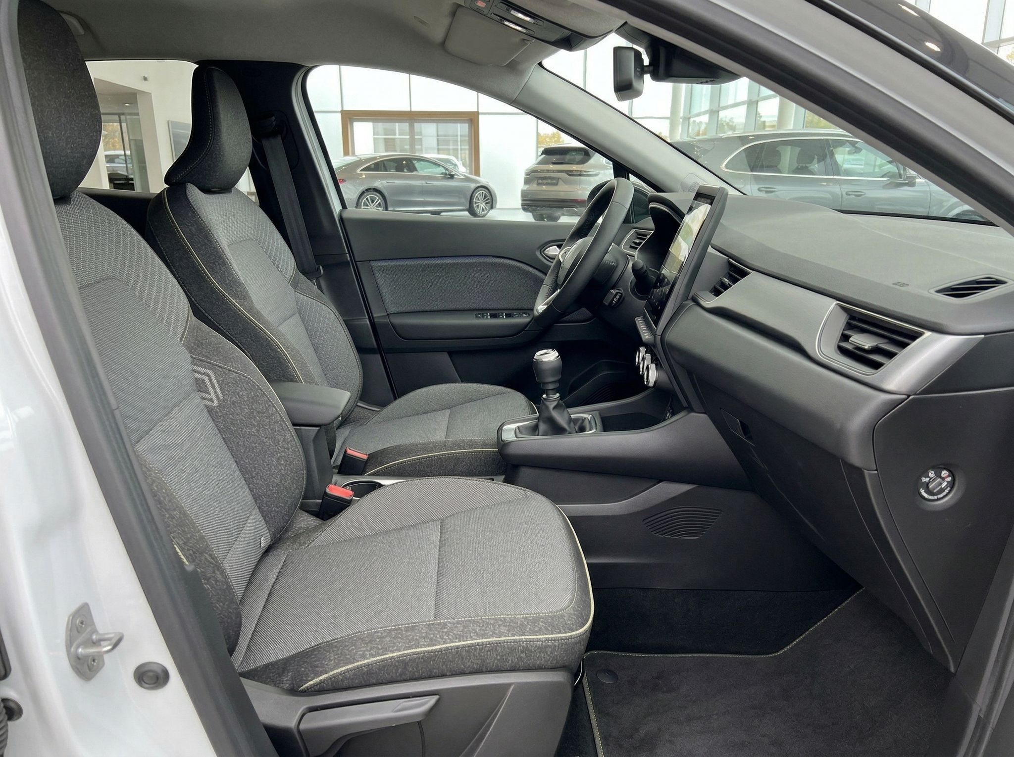 Fahrzeug Vordersitze und Beifahrerbereich mit grauer Polsterung und Mittelkonsole