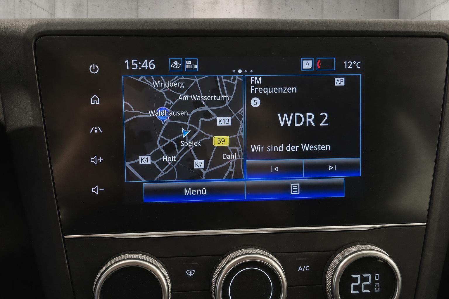 Infotainment-Display mit Navigationskarte und Radiosender im Fahrzeug