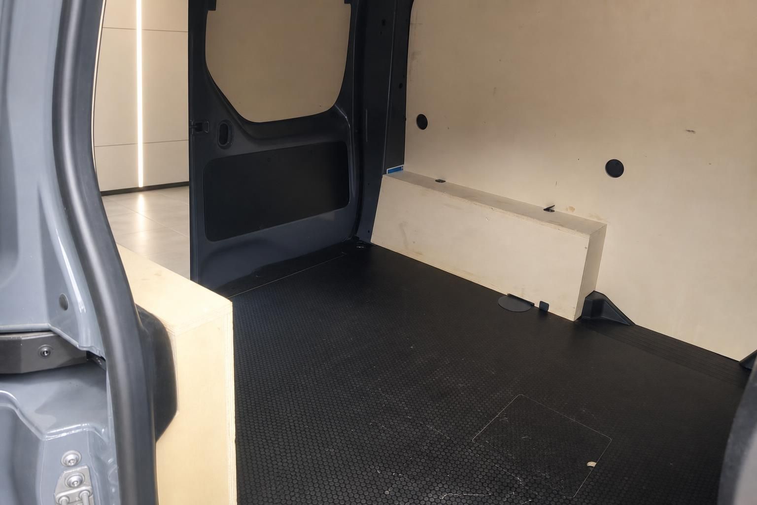 Transporter Laderaum - geöffnete Hecktüren mit schwarzem Ladeboden und weißen Seitenwänden