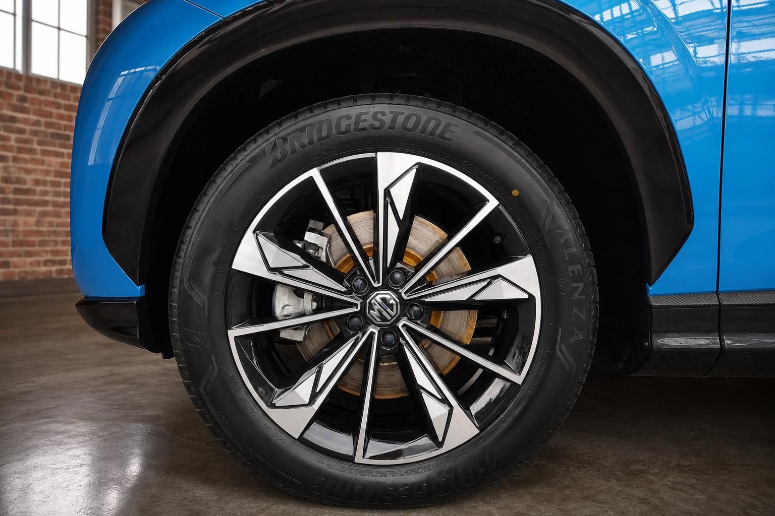 MG SUV blau – Detailaufnahme Leichtmetallfelge mit Bridgestone Alenza Reifen und Bremsscheibe