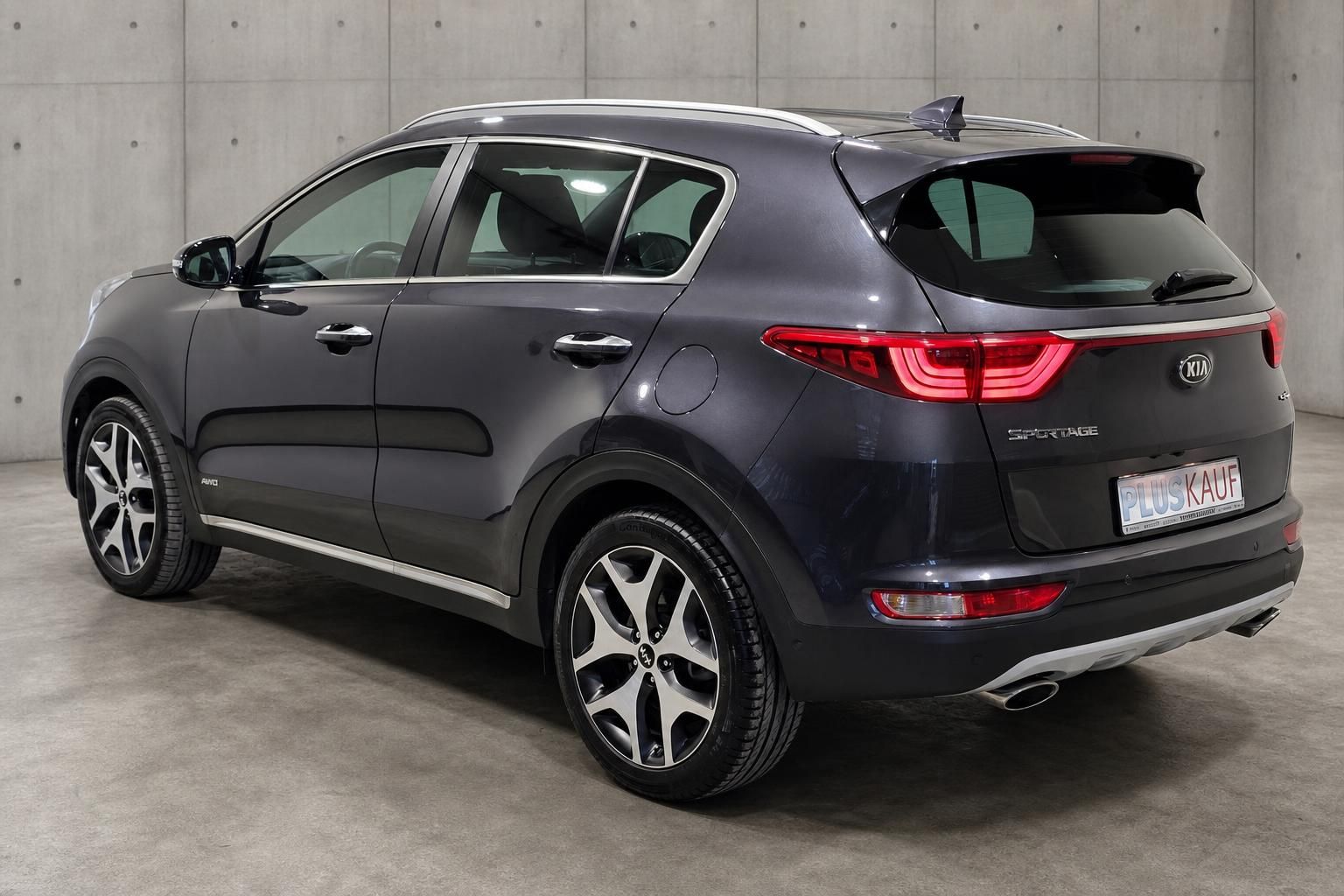Kia Sportage GT-Line grau, Heckansicht mit Seitenprofil im Studio