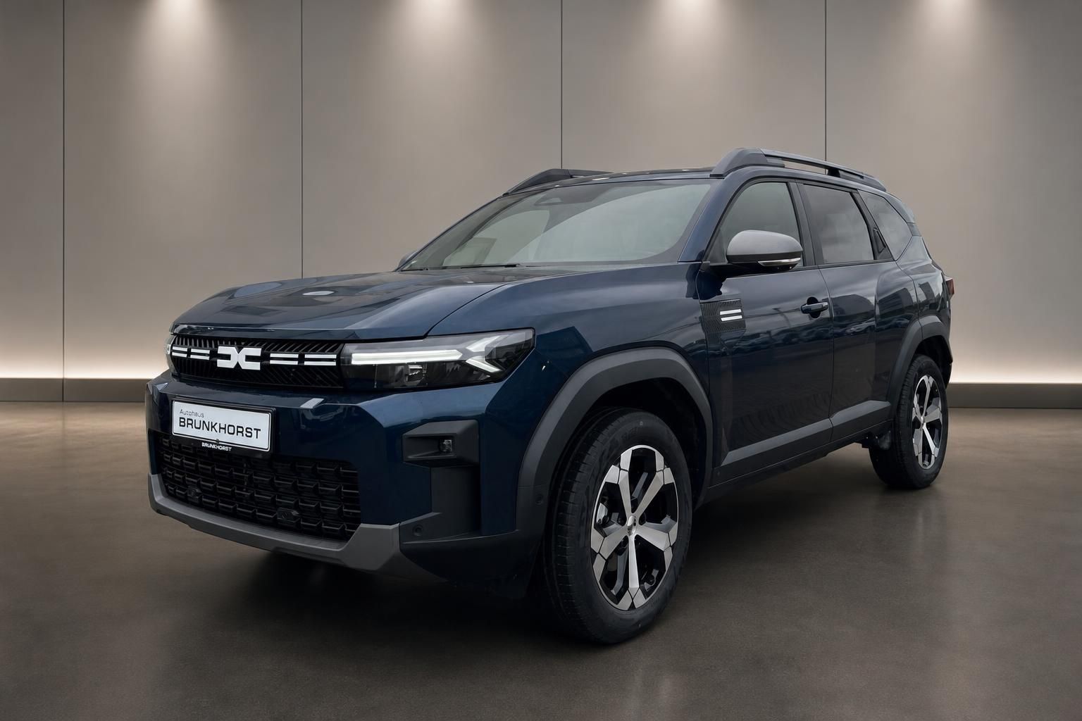 Dacia SUV in blau - Seitenansicht zeigt modernes Design und Alufelgen im Autohaus Showroom