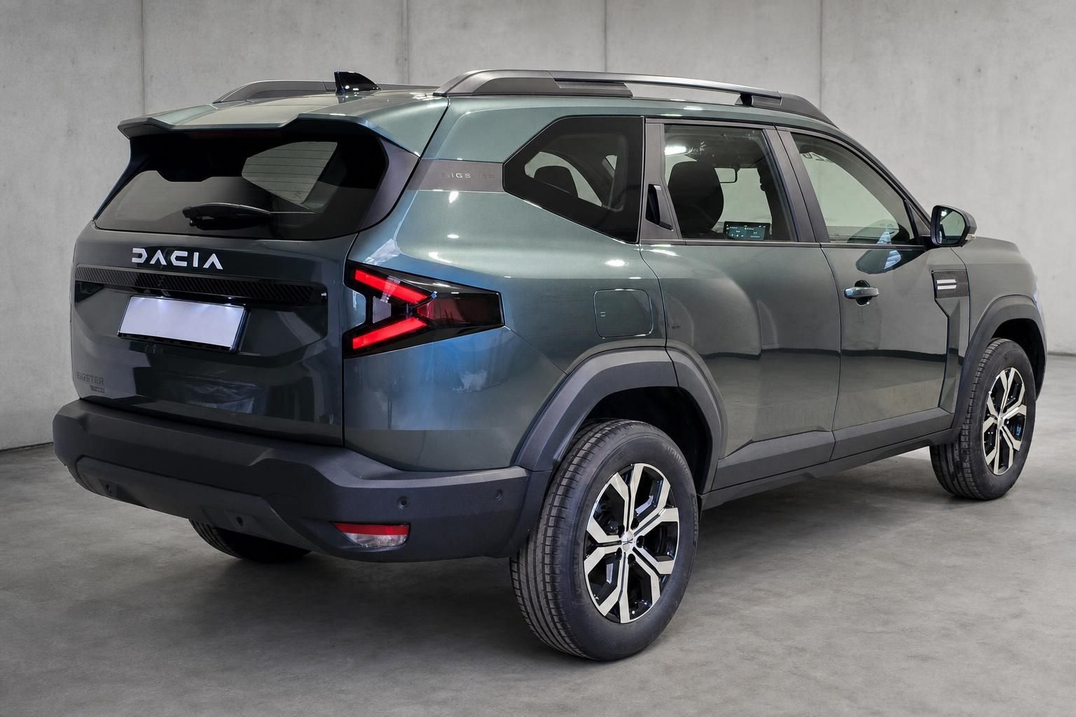 Dacia Bigster SUV grau-grün, Heckansicht seitlich in Halle