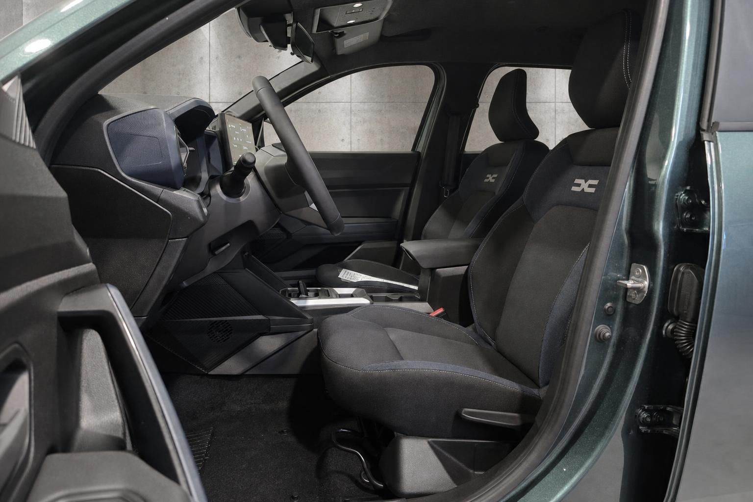 Vordersitze und Cockpit-Ansicht durch geoeffnete Fahrertuer im Fahrzeuginnenraum