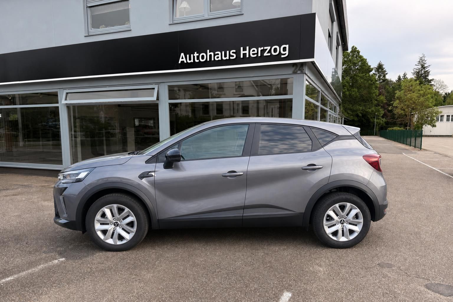 Grauer Mitsubishi SUV Seitenansicht vor Autohaus Herzog - kompakter Crossover mit Alufelgen