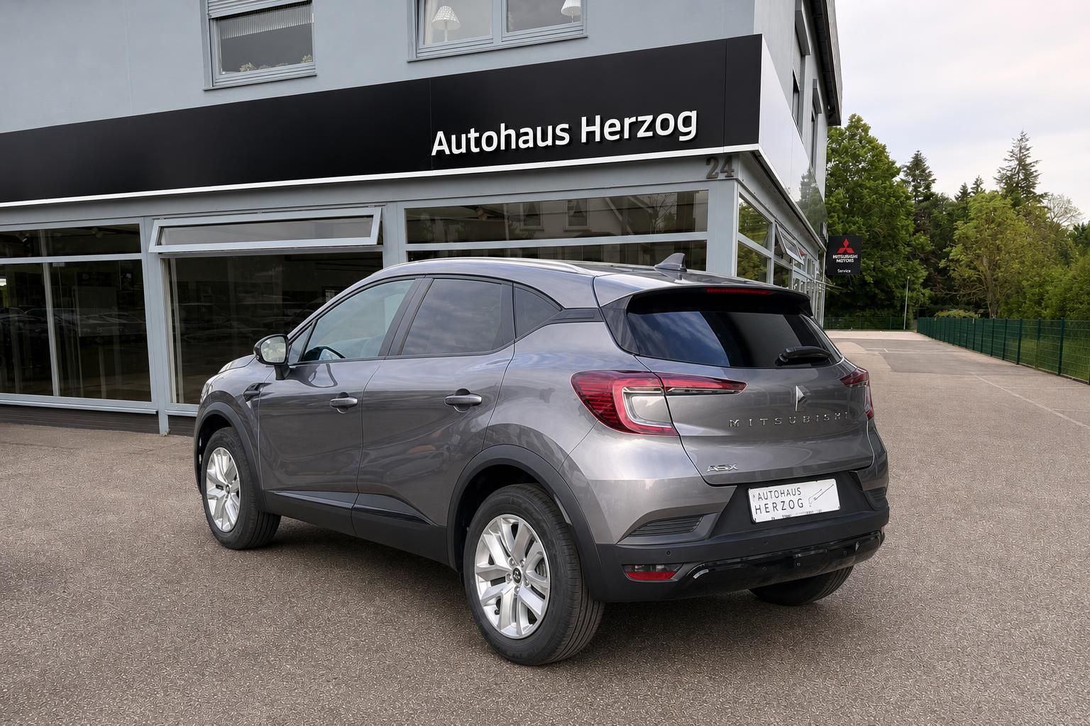 Grauer Mitsubishi SUV Heckansicht vor Autohaus Herzog - kompakter Crossover von hinten