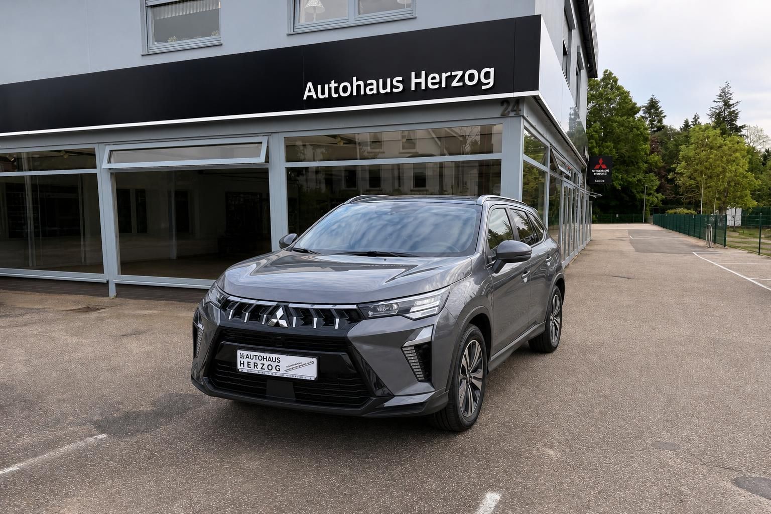Grauer Mitsubishi SUV Frontansicht vor Autohaus Herzog - moderner Crossover mit markanter Front