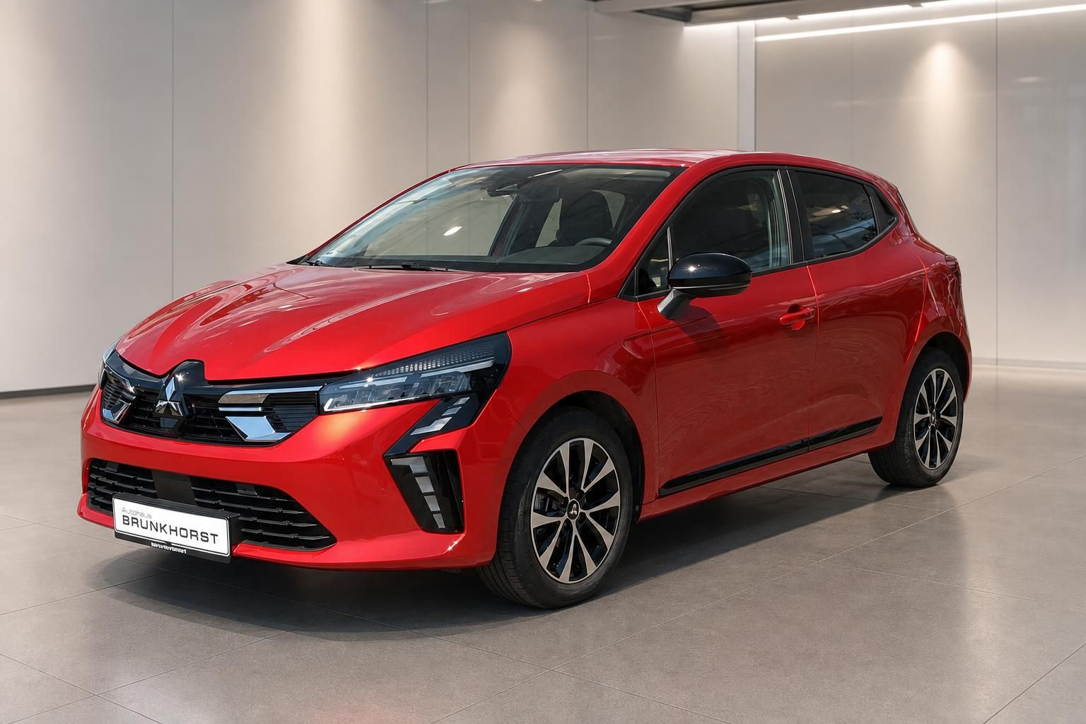 Roter Mitsubishi Colt - Schrägansicht von vorne links bei Brunkhorst mit modernem Showroom-Design im Hintergrund