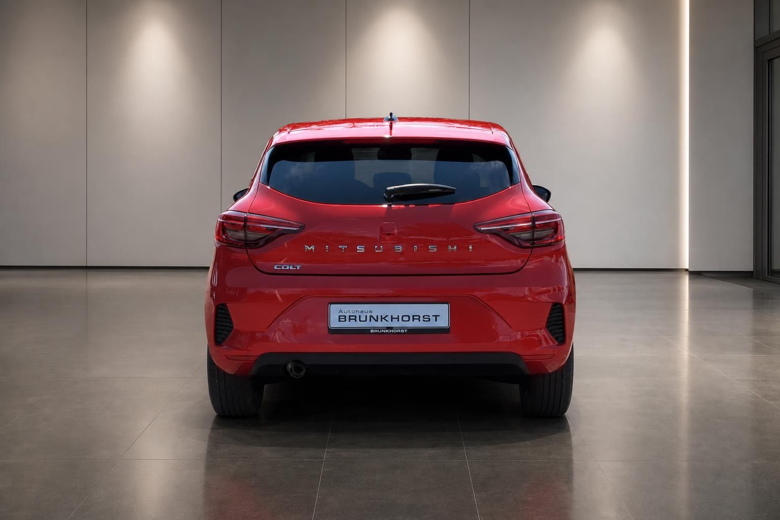 Roter Mitsubishi Colt - Heckansicht des Kompaktwagens bei Autohaus Brunkhorst in elegantem Showroom-Ambiente