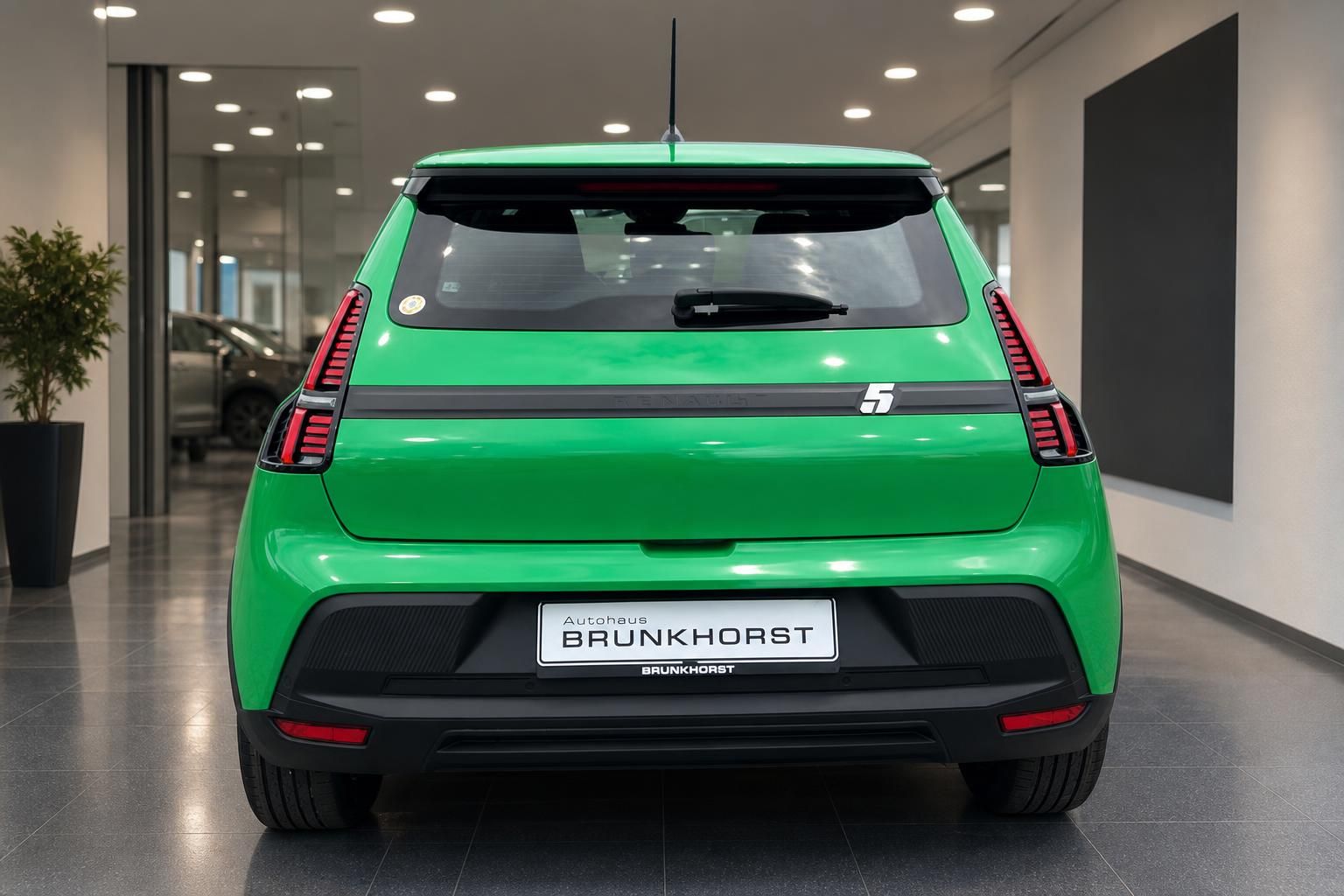 Grüner Renault Elektro-SUV Heckansicht mit LED-Rückleuchten im Autohaus Showroom