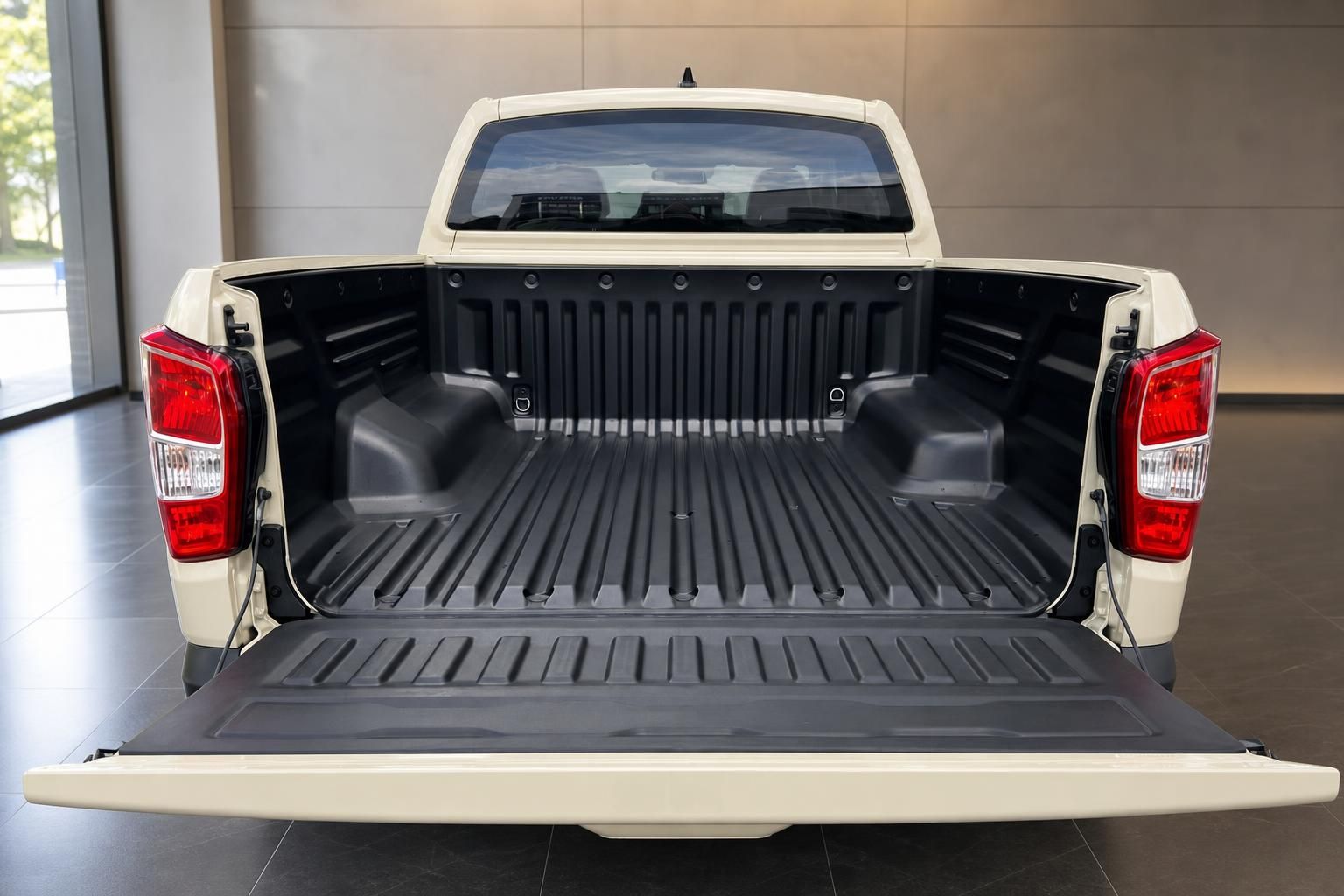 Offene Ladefläche eines weißen Pickup-Trucks mit schwarzer Auskleidung im Autohaus