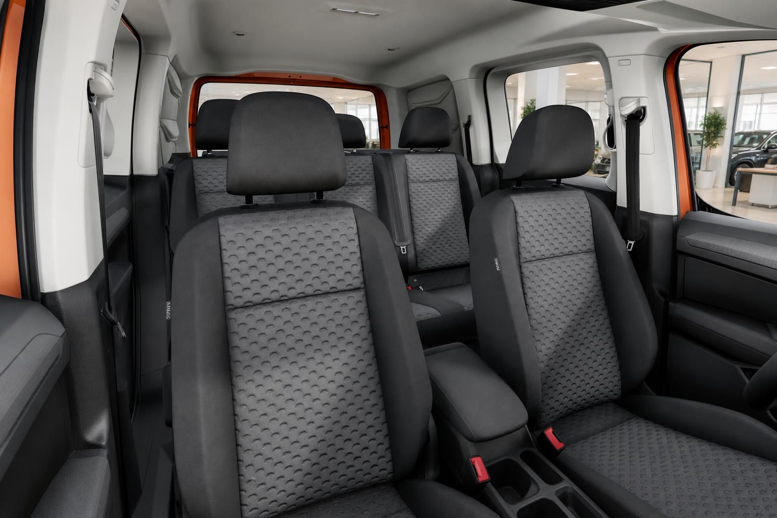 VW Caddy Innenraum mit Sitzreihen und Panoramablick auf Autohaus
