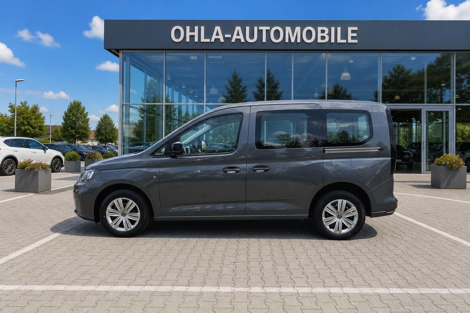 VW Caddy grau Seitenansicht vor Autohaus Ohla-Automobile