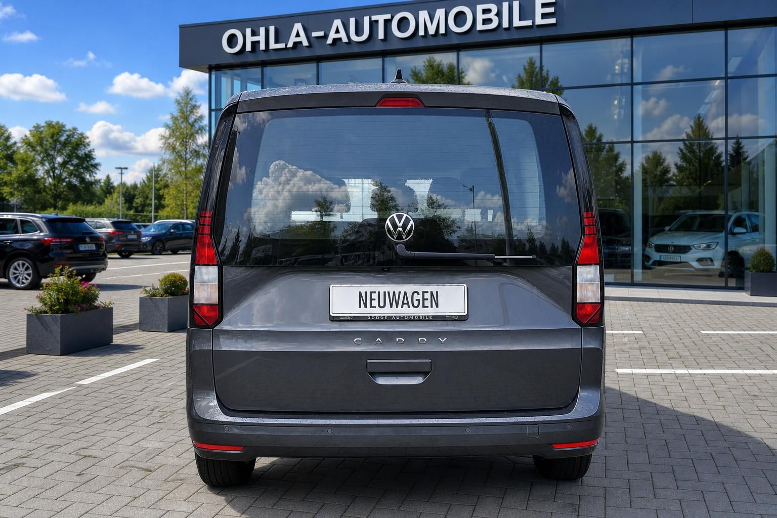 VW Caddy grau Heckansicht vor Autohaus Ohla-Automobile